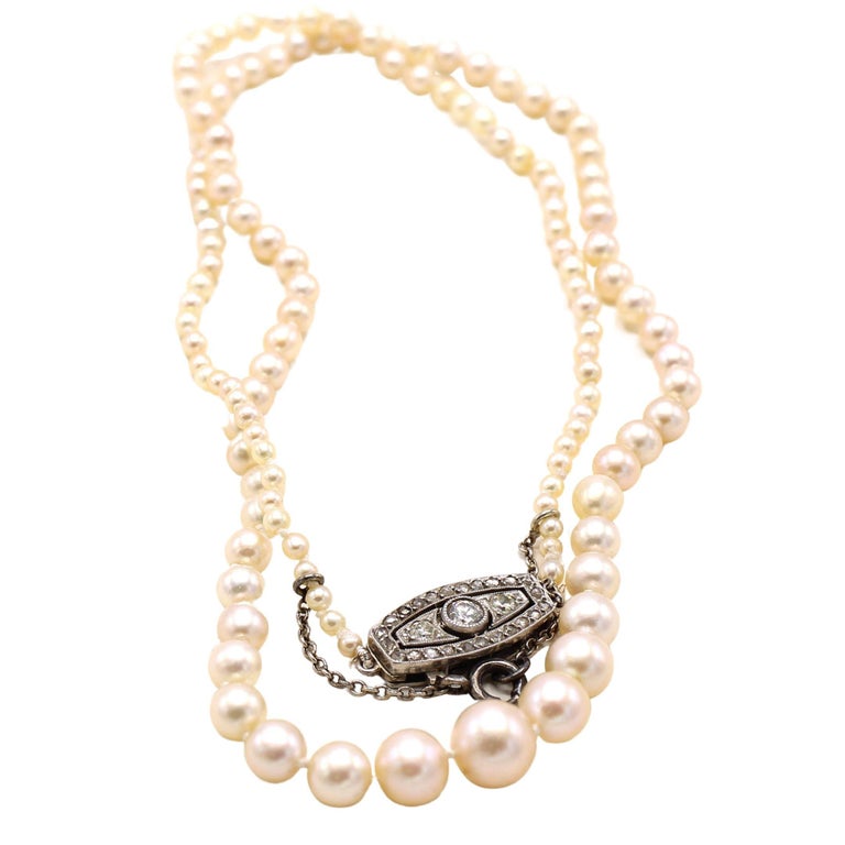 Beautiful and lustrous strand of pinkish natural saltwater pearls ranging up to 6.90 millimeters with a 18 karat white gold diamond clast. French assay marks and numbers on clasp. Length 18 inches. Accompanied by a report from the GIA