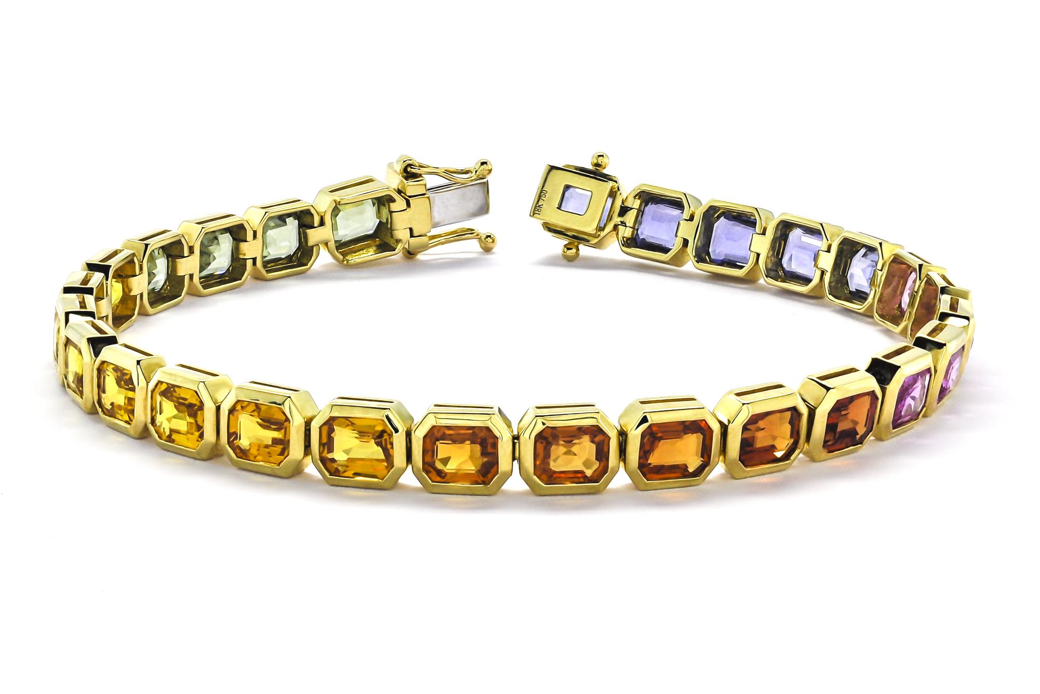 Adorn your wrist with the captivating allure of this exceptional bracelet, meticulously crafted to showcase a dazzling array of colorful sapphires in vibrant shades of orange, yellow, blue, and green. Each sapphire is carefully selected for its