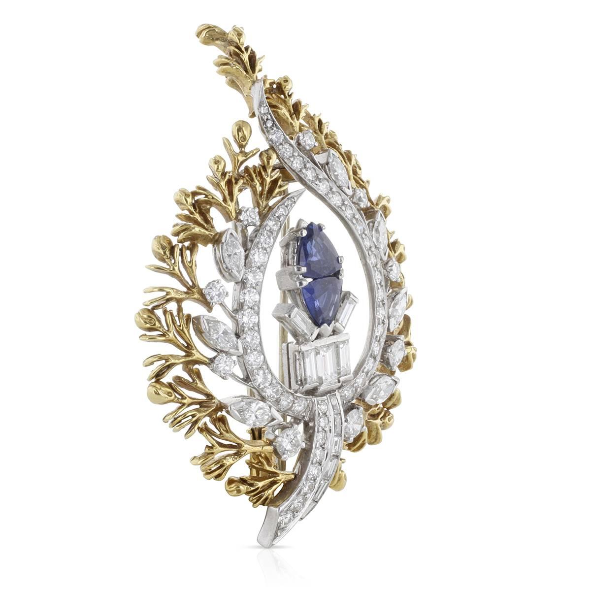 This vintage style dazzler centers two vivid trilliant-shaped sapphires and sizzles with 3.80 carats in diamonds. It's beautifully handcrafted in platinum and yellow gold and shaped in an elaborate leaf style fashion which was so popular back in the