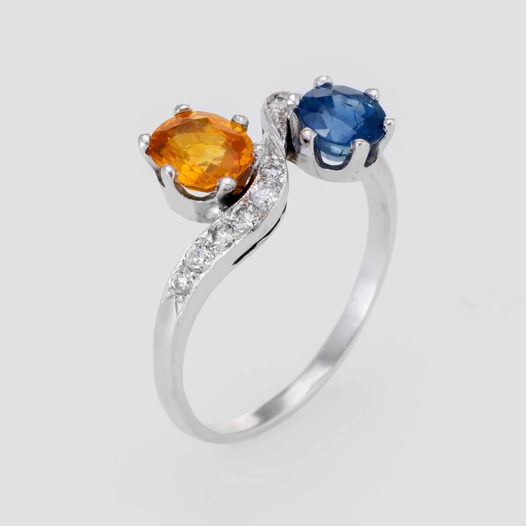 Elegant vintage bypass ring (circa 1950s to 1960s), crafted in 18 karat white gold. 

One round mixed cut Natural Sapphire, approx. 0.90 carats (5.5 x 3.7mm), dark blue color, moderately included, good cut, Sri Lanka origin, heated. One oval mixed