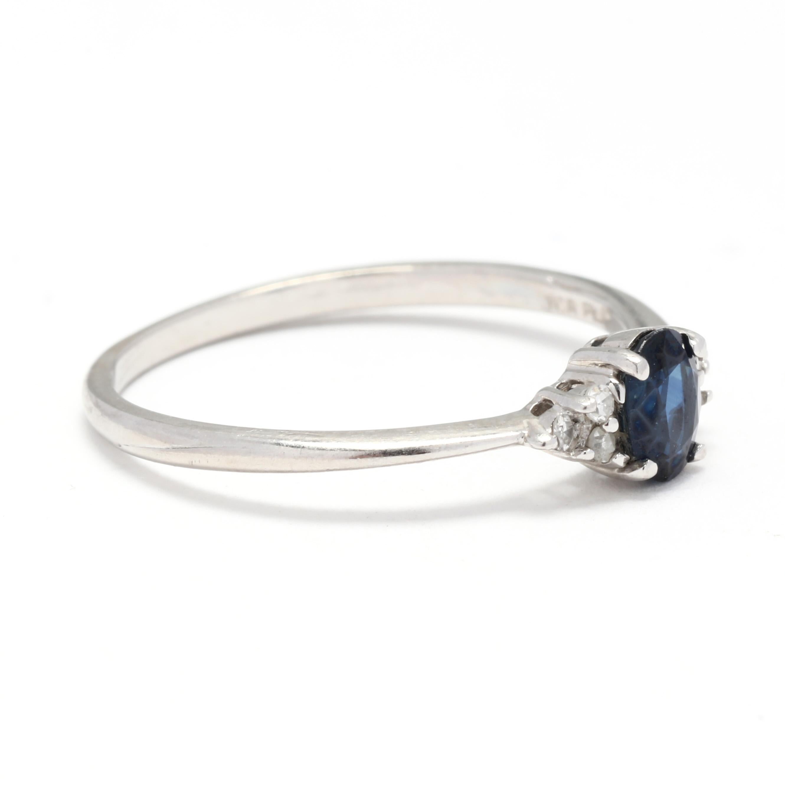 A platinum natural sapphire and diamond engagement ring. This small ring features a prong set, oval cut sapphire weighing approximately .50 carat with three single cut round diamonds weighing .05 total carats on either side and with a tapered