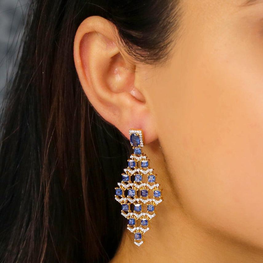 Questi orecchini sono realizzati in oro giallo 18 carati massiccio e sono incastonati con gemme di zaffiro e diamanti. Gli orecchini pendono dal lobo dell'orecchio e sono una bellissima aggiunta a qualsiasi abbigliamento.

Specifiche:

Dimensioni: