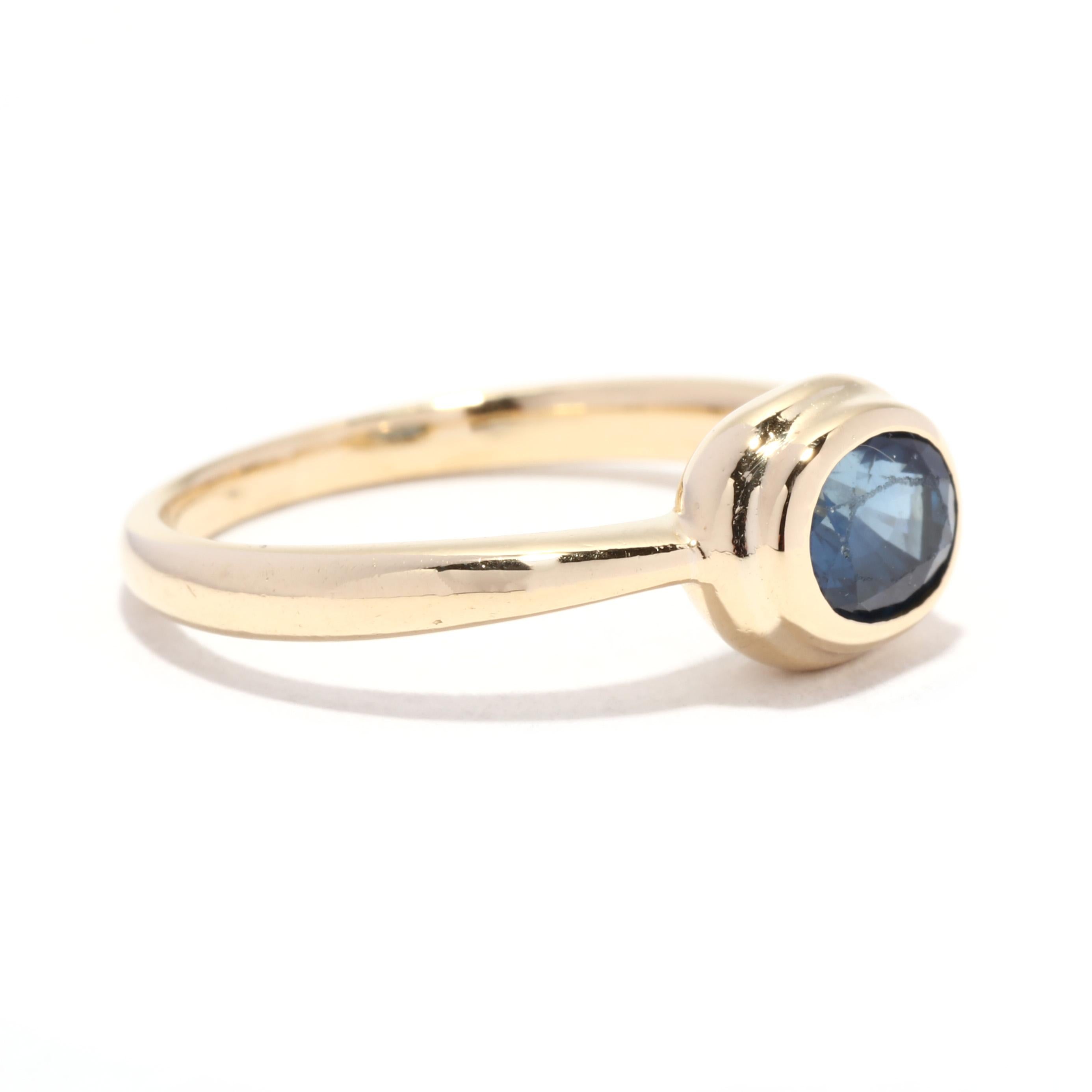 A vintage 18 karat yellow gold natural sapphire engagement ring. This September birthstone ring features a horizontal bezel set, oval cut sapphire weighing approximately 1.16 carat and with a tapered band.

Stones:
- sapphire, 1 stone
- oval cut
-