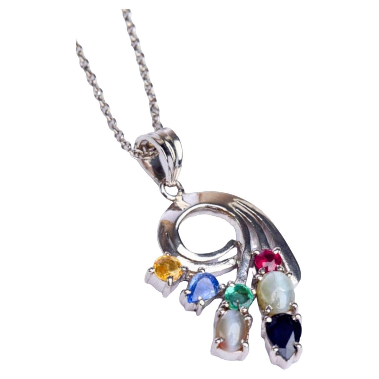 Elaborado con exquisita atención al detalle, este colgante Multi-gema presenta una cautivadora combinación de piedras preciosas naturales, como rubí, zafiros, esmeralda y ojos de gato. 

El tono rojo fuego y la representación simbólica de la pasión