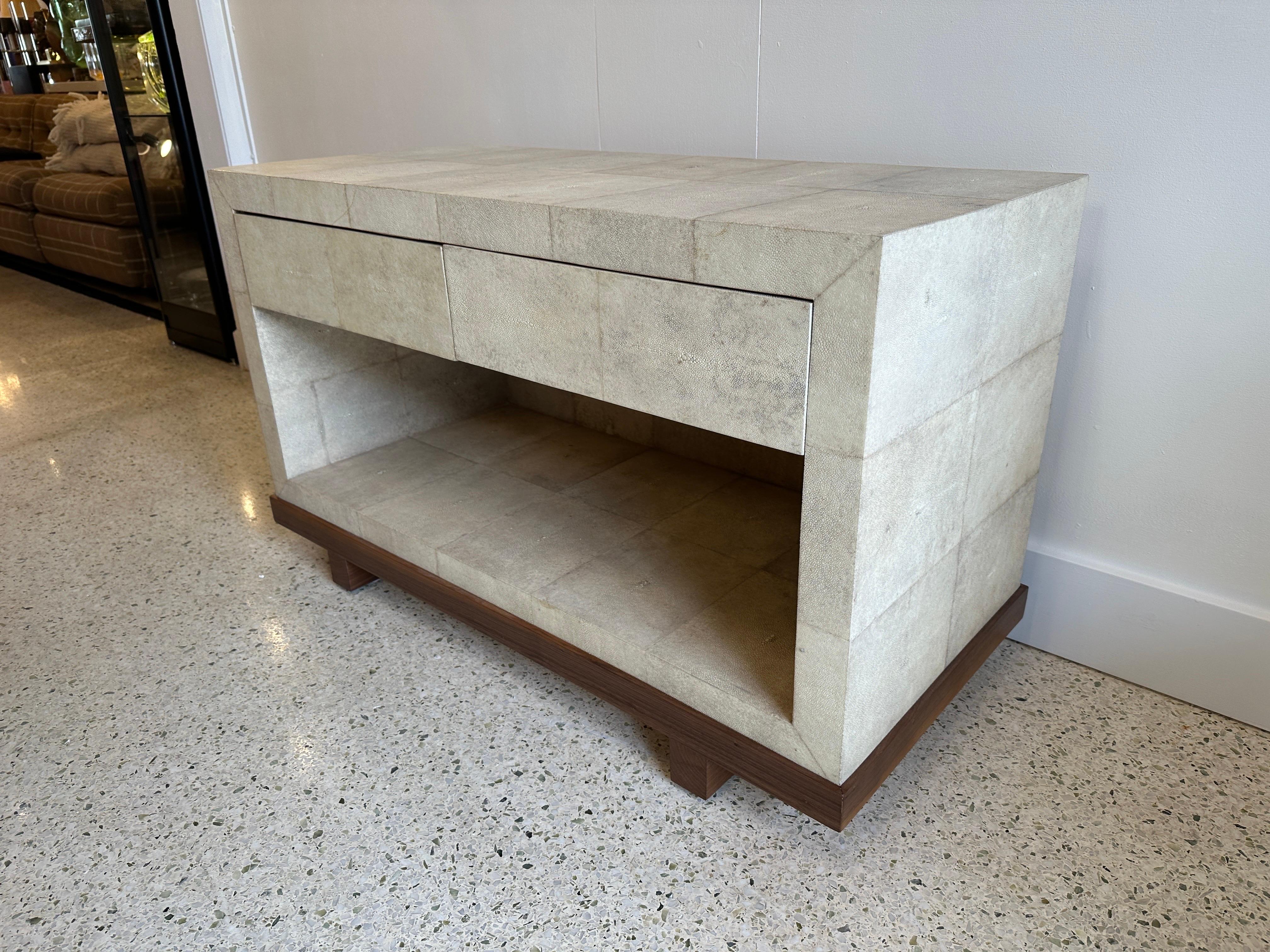 This two-drawer cream covered shagreen low console by R&Y Augousti (metal tag to drawer interior) is an elegant piece. This bedside table or low TV console features two drawers and a lower open shelf atop a natural mahogany wood base.  All R&Y