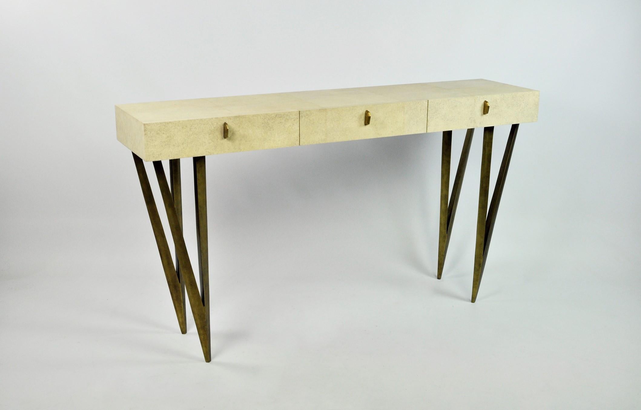 The console table REEF is made of natural shagreen (our ref ANTIC).
It has three drawers and the legs have an old brass patina.
The knobs are made in lost wax cast brass.

This console will settle very well in your entrance or your living room.