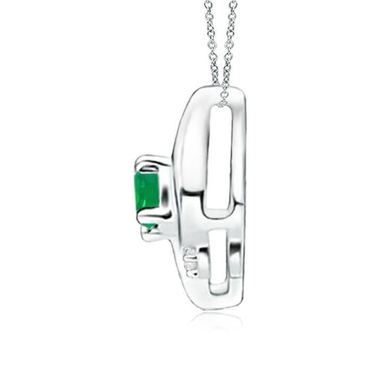 This gorgeous pendant features an alluring conch-like frame that holds a lush green emerald. Sparkling round diamond accents add to the overall allure of the design. This oval emerald and diamond pendant is designed in enduring 14k white gold.