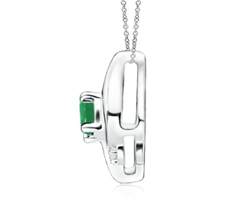 Ce magnifique pendentif présente un cadre en forme de conque qui renferme une émeraude d'un vert luxuriant. Des diamants ronds étincelants ajoutent à l'allure générale du modèle. Ce pendentif ovale en émeraude et diamant est conçu en platine