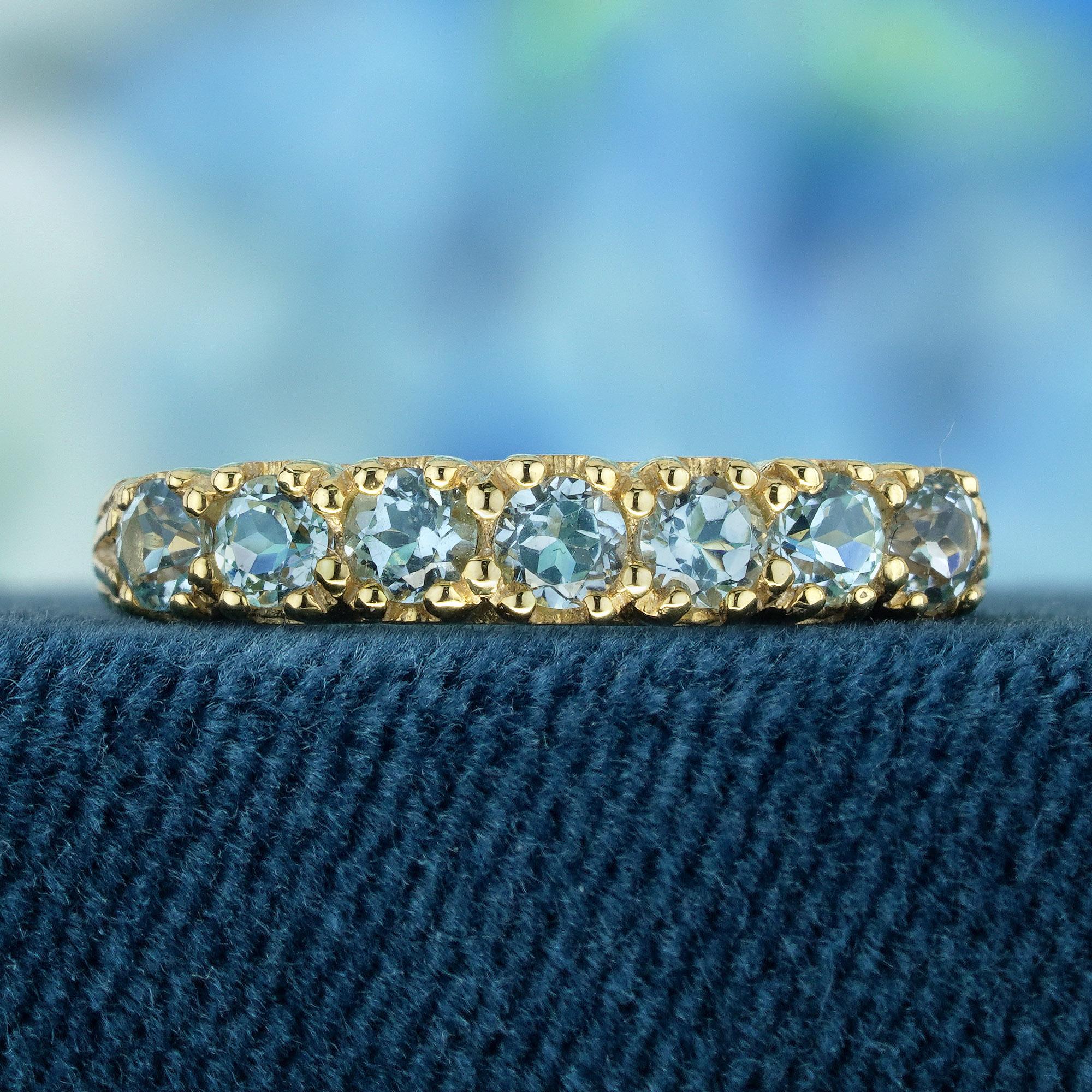 This ring embodies a vintage flair, showcasing intricate details and an ageless appeal. Its yellow gold setting provides a cozy and opulent base for the gemstones. Nestled at the core of the ring are half eternity of natural  round blue topaz,