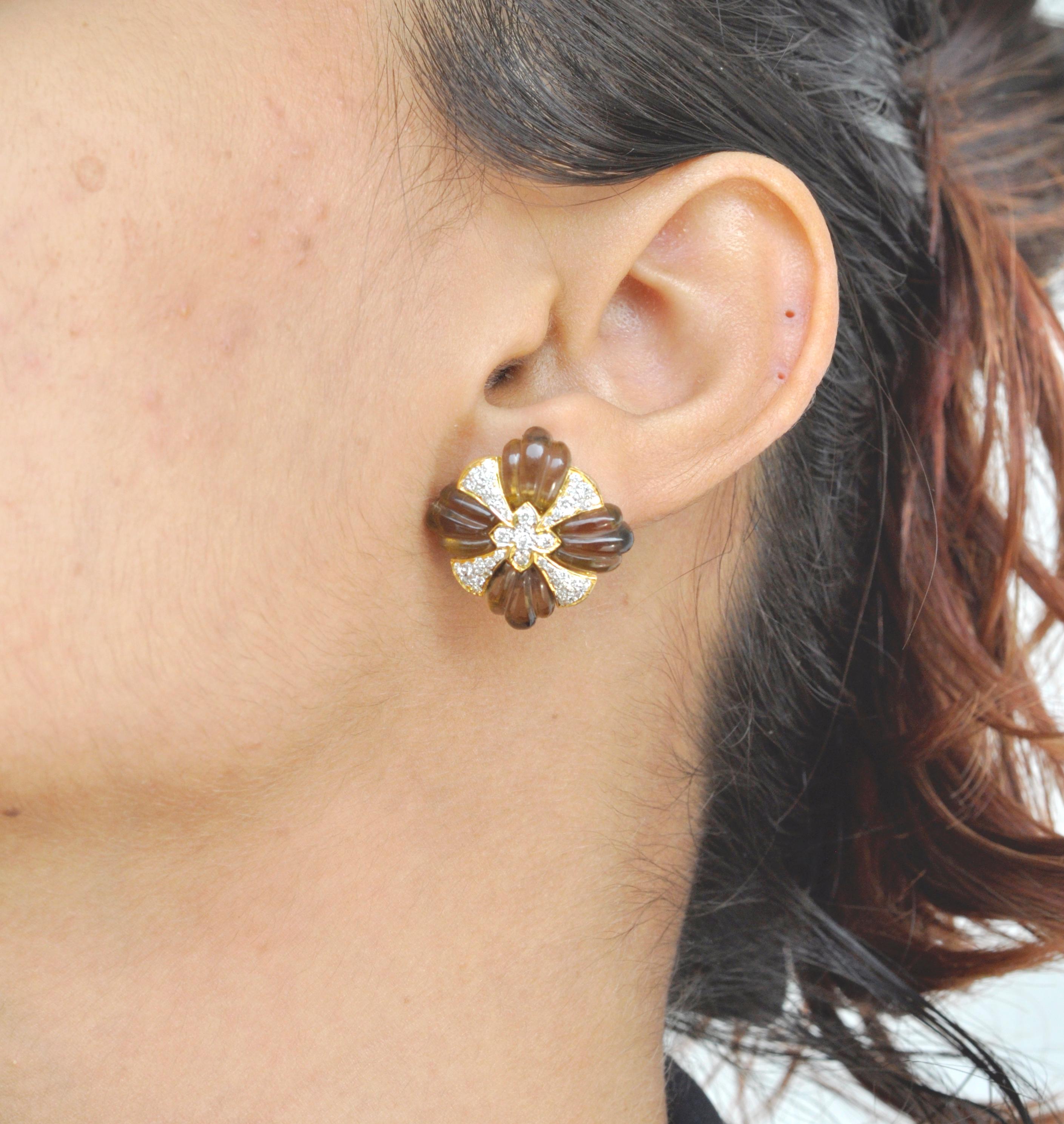 A beautiful classic yet unique smoky quartz carving stud earring is a chic piece to have in your jewelry closet. The earrings uses 18 Karat yellow gold with diamonds and smoky quartz carving precisely set in the shape of a wheel complimented by pave