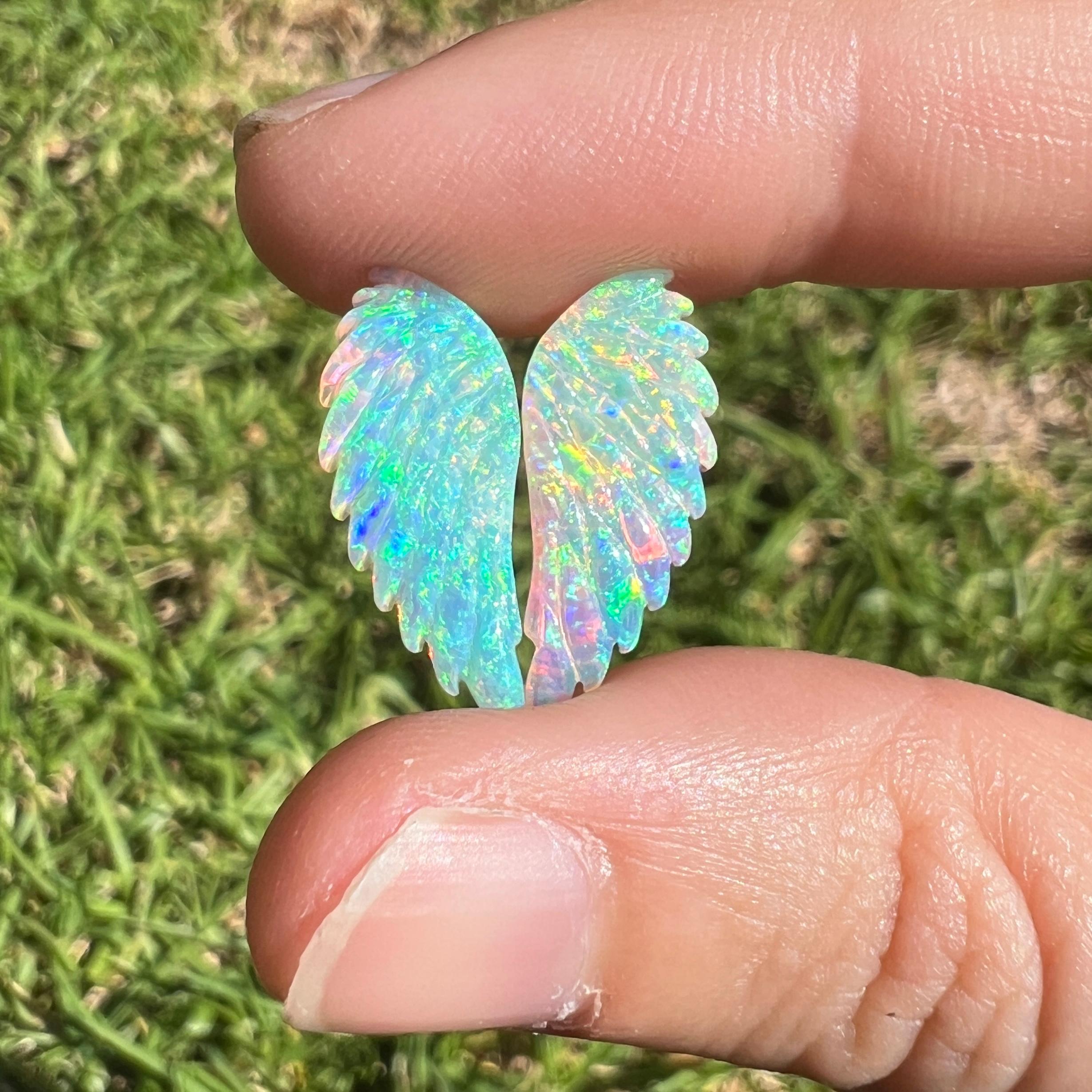 This 4.92 Ct natural Australian gem crystal opal, carved into a pair of angel wings, is a truly exceptional addition to any collection, mined by Sue Cooper herself. Its rarity, coupled with the amazing winged carving, captivates connoisseurs with