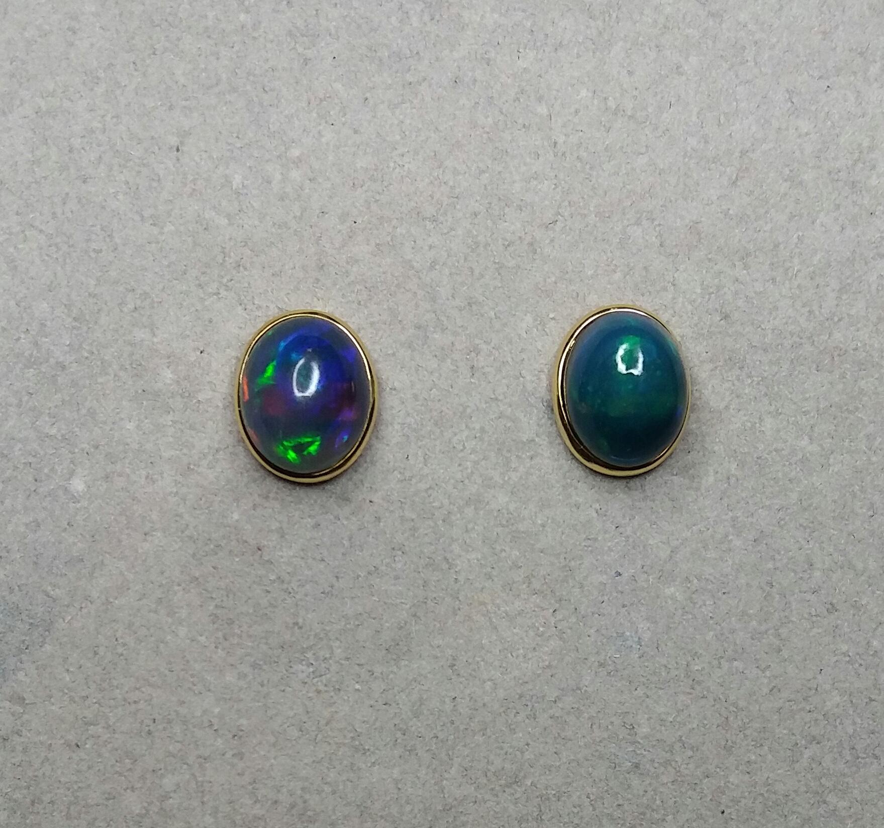 Simple and elegant pair of Black Opal Oval Cabochons measuring 12x10 mm. in  a 14 Kt yellow gold bezel setting.

In 1978 our workshop started in Italy to make simple-chic Art Deco style jewellery, completely handmade and using the typical gemstones