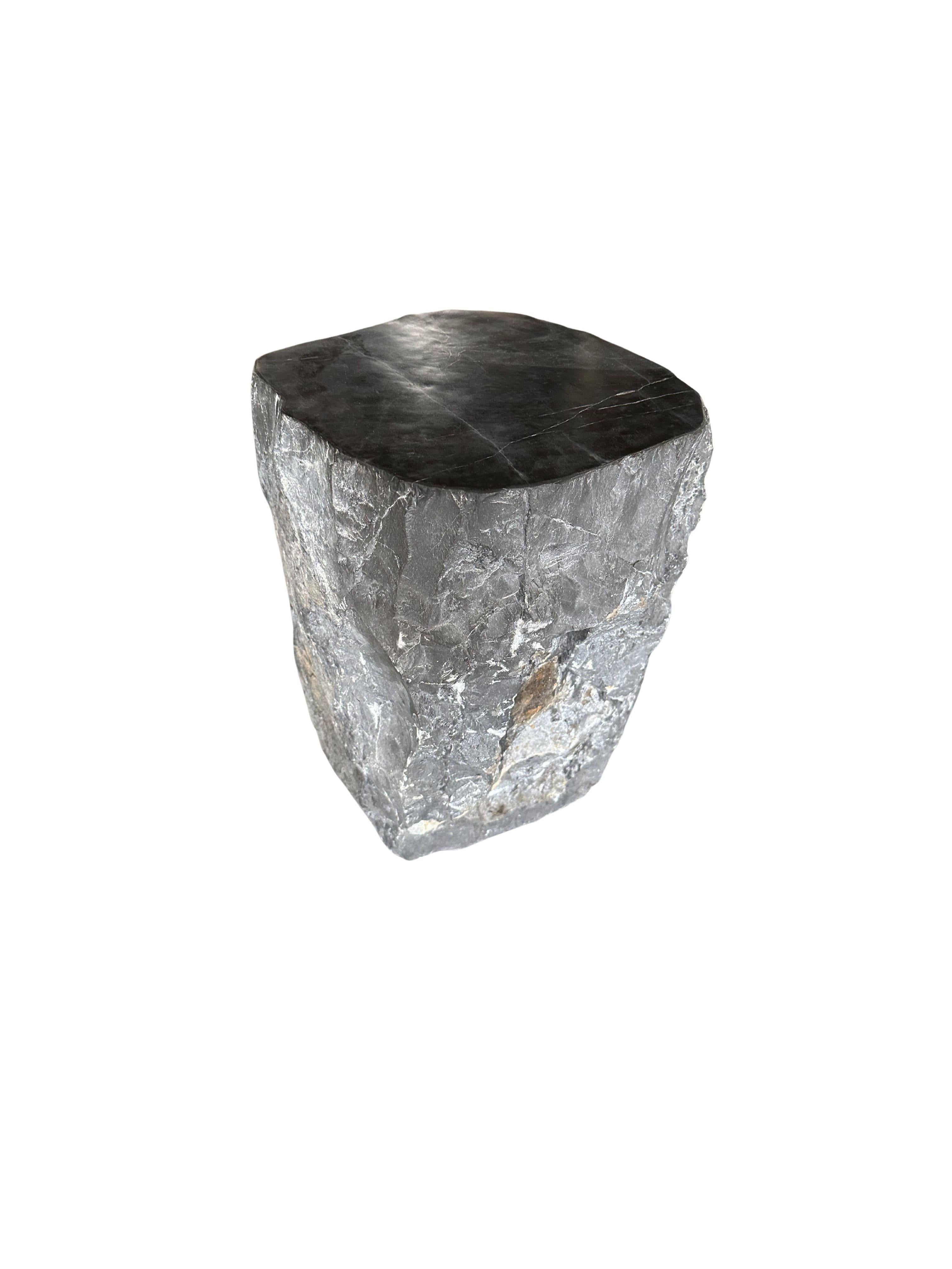 A wonderfully organic solid marble side table with a polished top and hand chiseled sides. The mix of textures and shades adds to its charm.