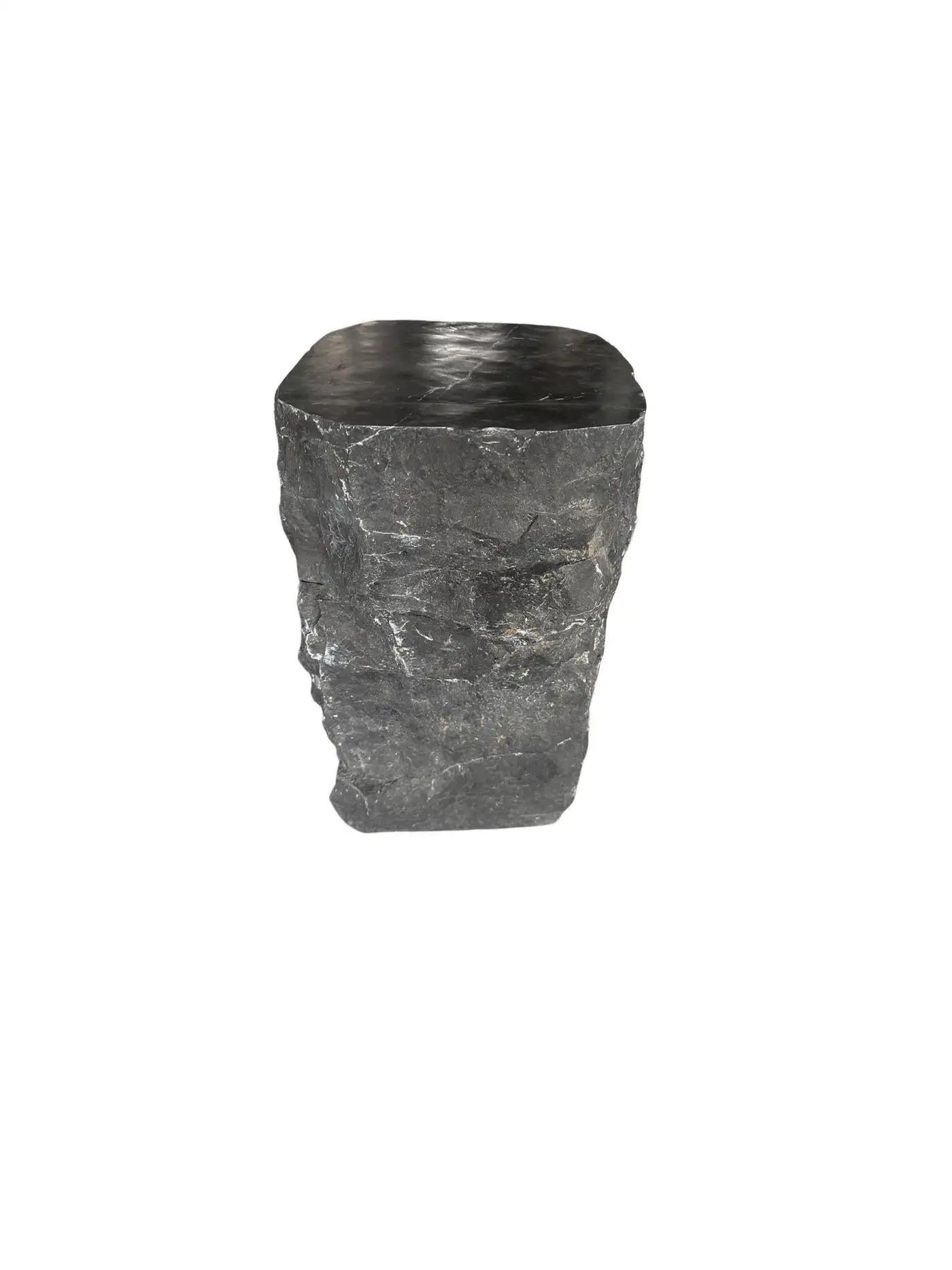 A wonderfully organic solid marble side table with a polished top and hand chiseled sides. The mix of textures and shades adds to its charm.