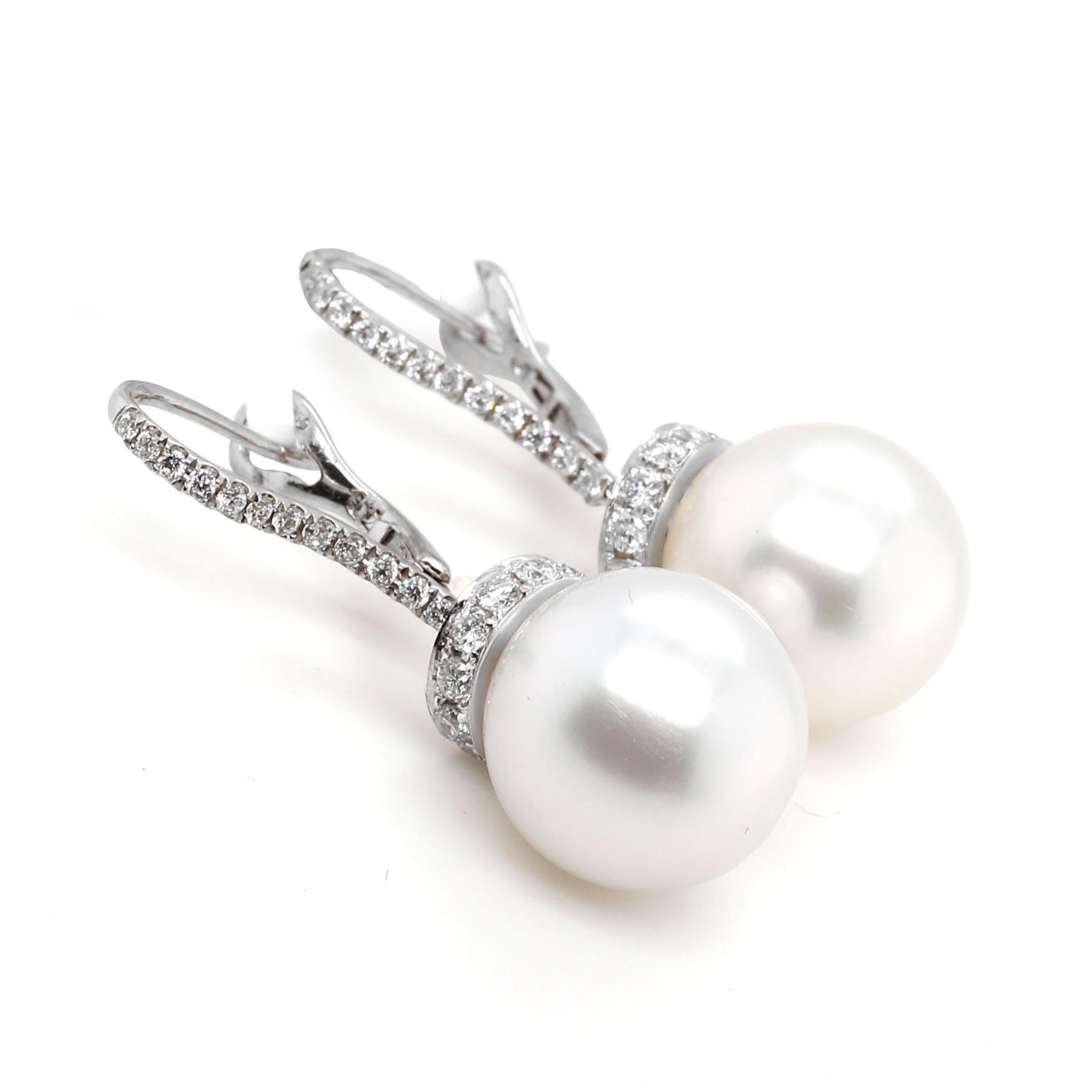 Earrings containing 2 natural South Sea Pearls of about 12.20mm and 48 round brilliant cut Diamonds of about 0.74 carats with a clarity of SI Color G. Al stones are set in a 14k white gold setting. The total weight of the earrings is approximately