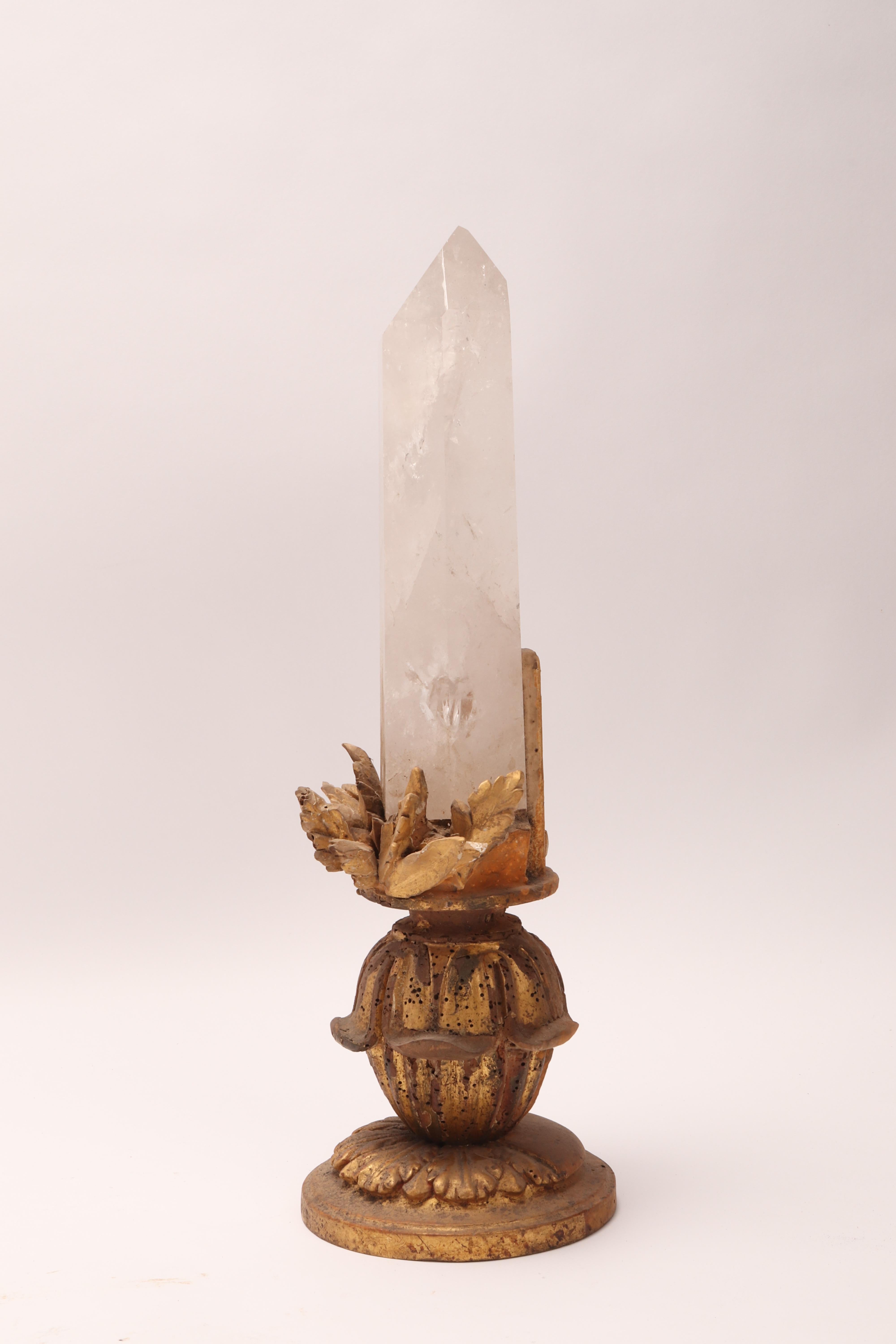 A Naturalia mineral specimen. A big rock crystal mounted over a carved wooden base gold gilt with carved leaves, Italy, circa 1880.