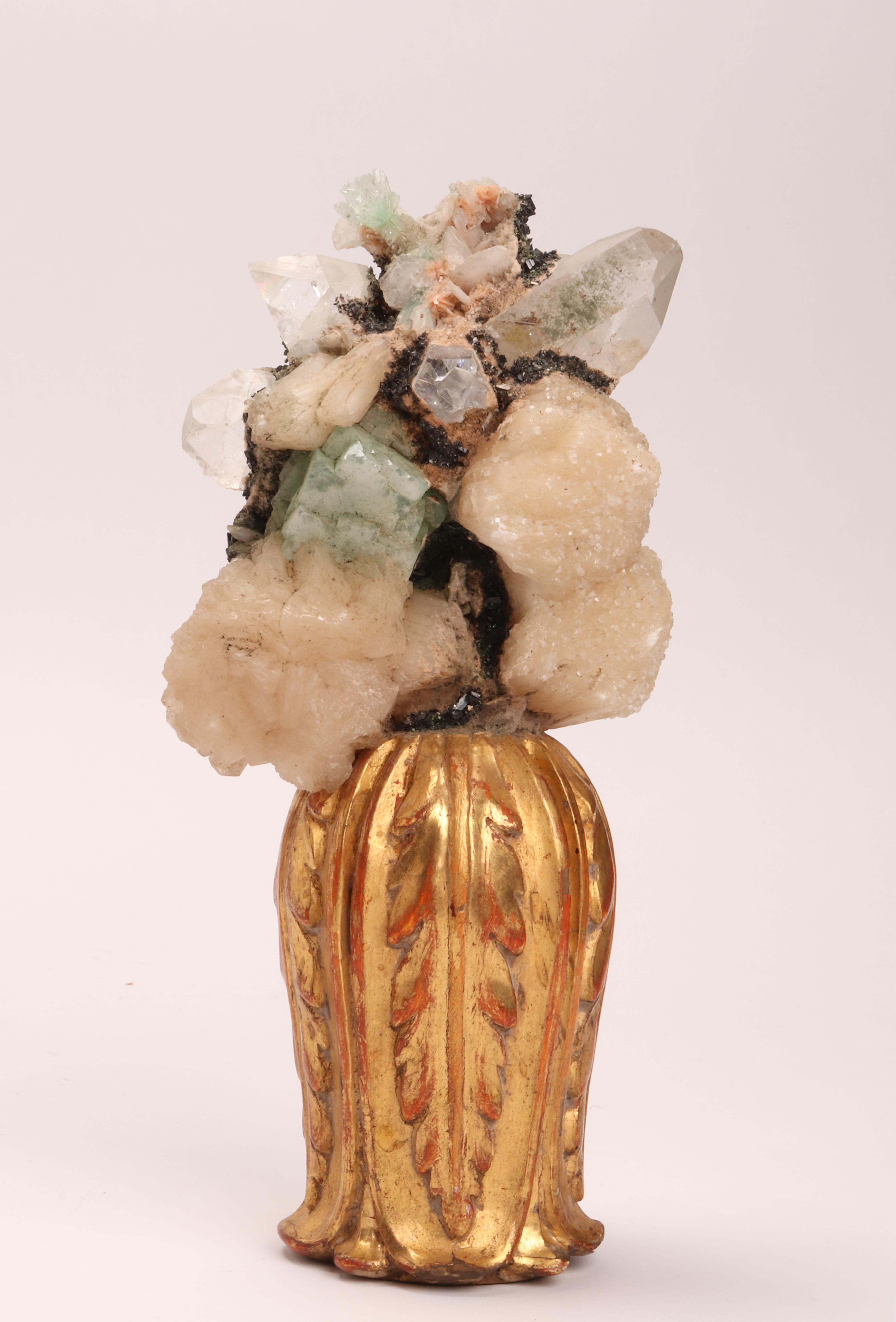 A natural mineral specimen for Wunderkammer. A pair of Apophyllite and white quartz druzes, mounted over carved wooden base, vase shape with leaves gold gilt. Italy, 1880 ca.