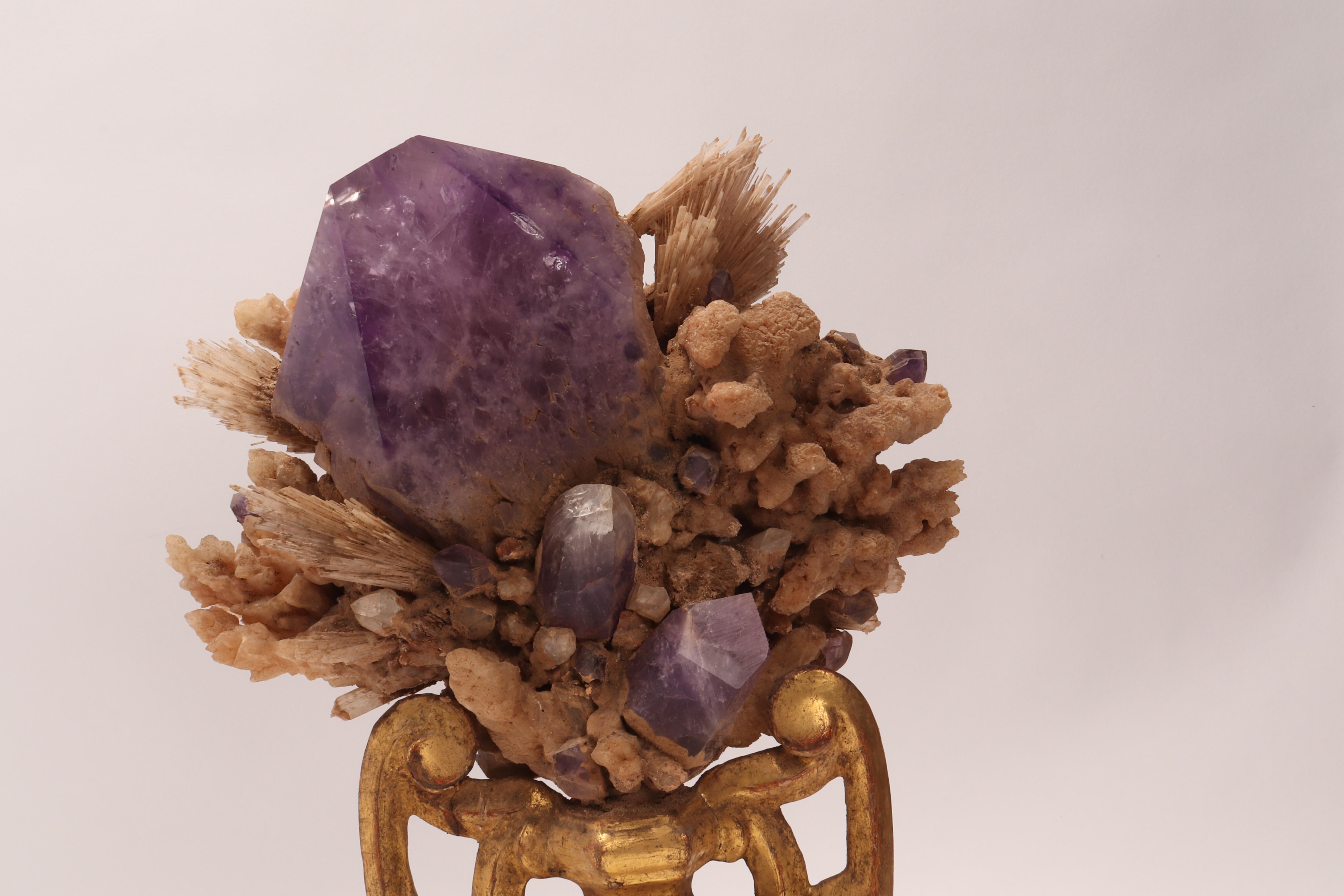 A Naturalia mineral specimen. A Druze of Amethiste, calcite, and calcite flowers crystals, mounted over a guild-plated wooden base on a vase shape, Italy, circa 1880.