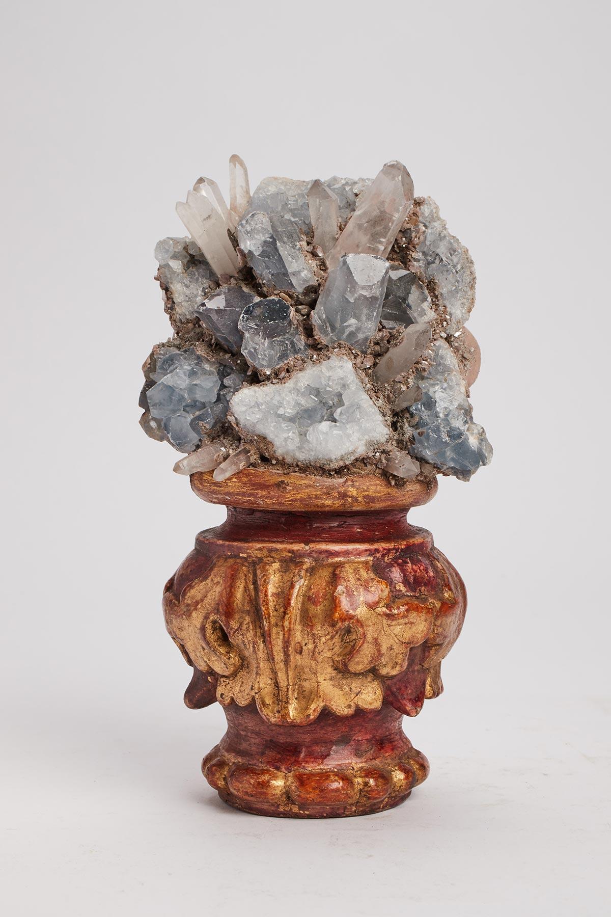 A Naturalia mineral specimen. Celestite or celestine crystals mounted over a carved wooden base gold gilt on a shape of a vase. Italy last part of 19th century.