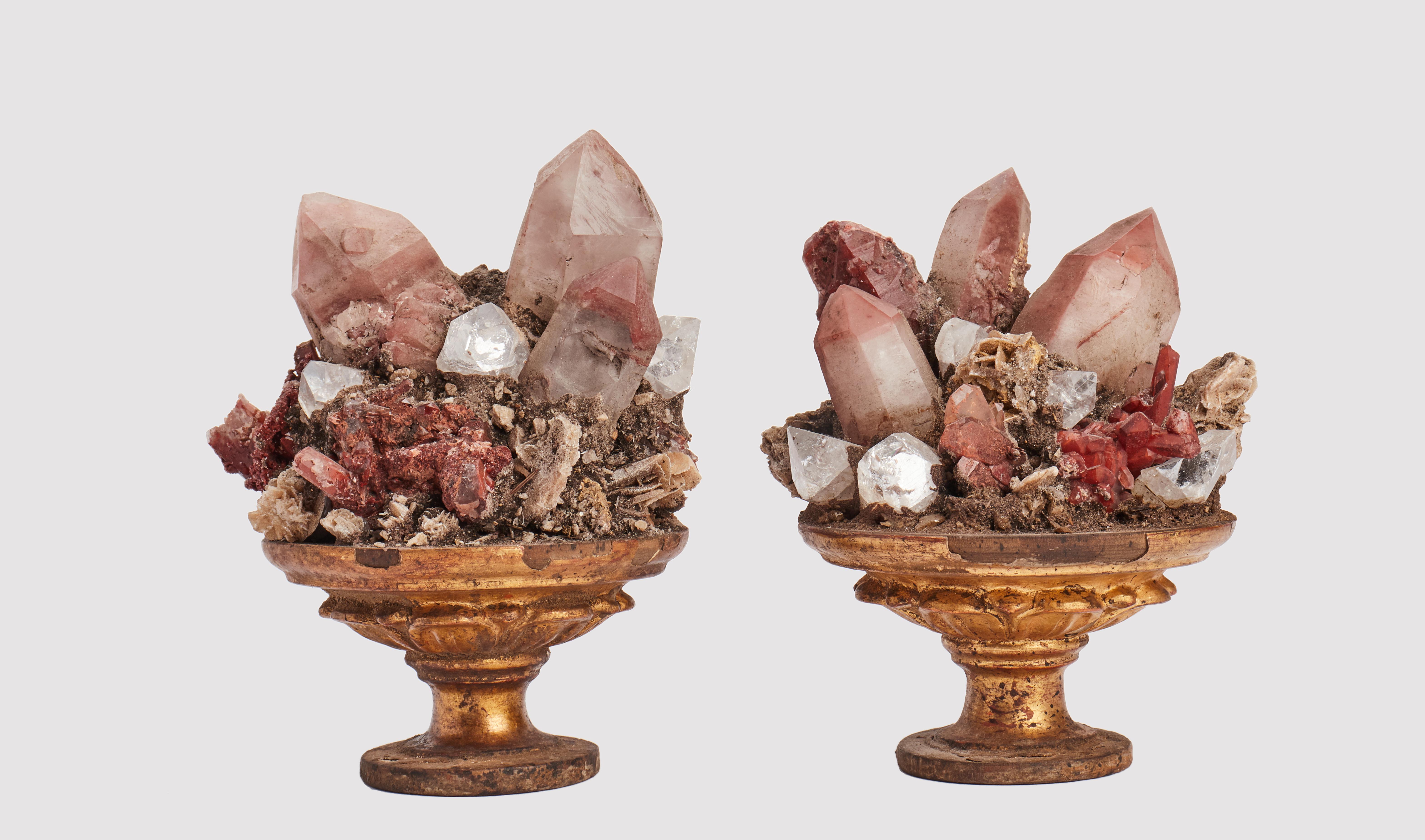 A Naturalia mineral specimen. A pair of red quartz, rock crystals and Apophilite druzes, mounted over a guild-plated wooden bases with leaves decoration on a shape of a vase. Italy last part of 19th century.