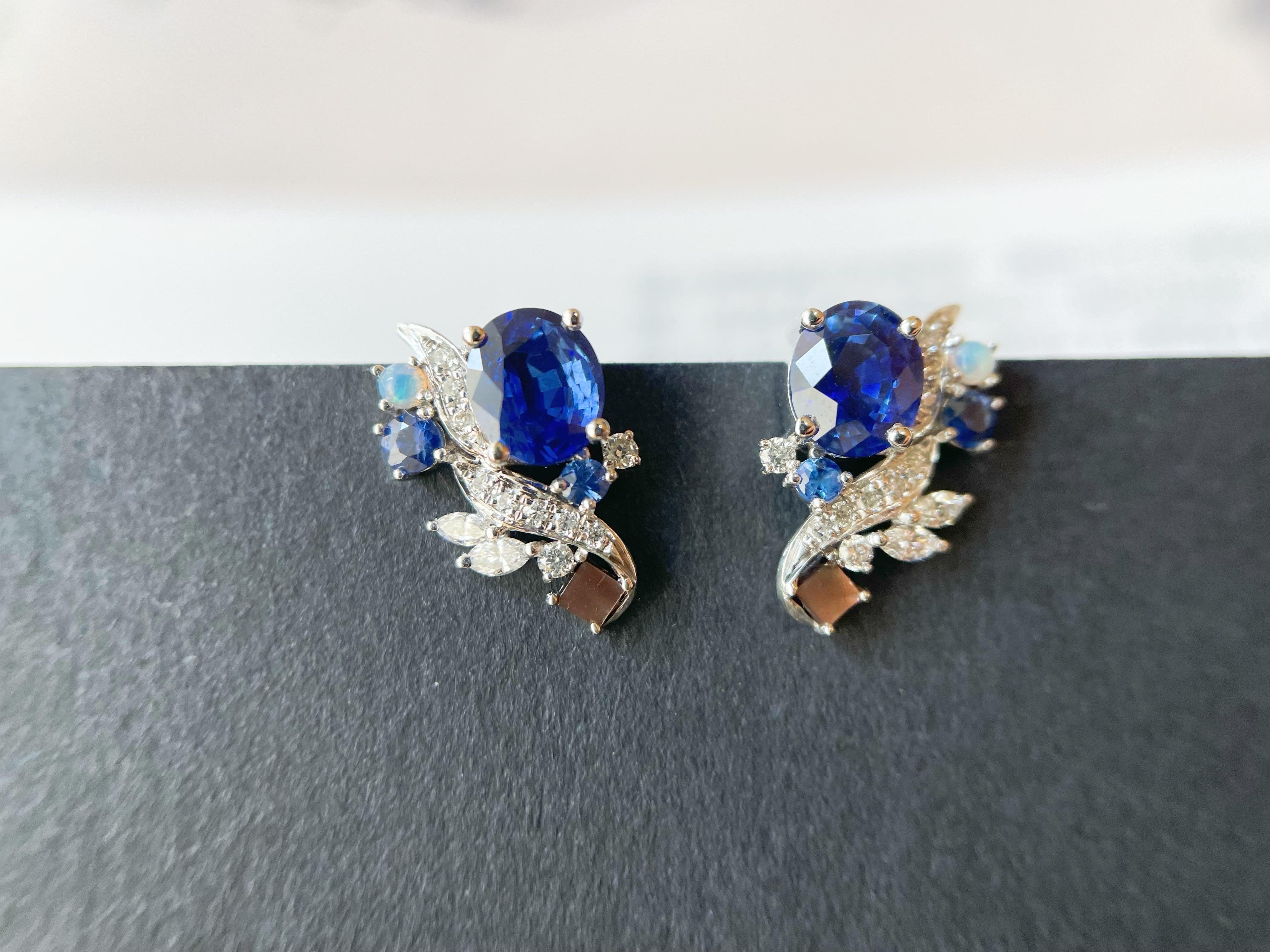 Two stunning natural Sri Lanka blue sapphires decorated by brilliant diamonds, opals, mother of pearls set in simple and modern design. The pair of earrings is custom-designed and is one-of-a-kind. The center natural sapphires are ethically mined in