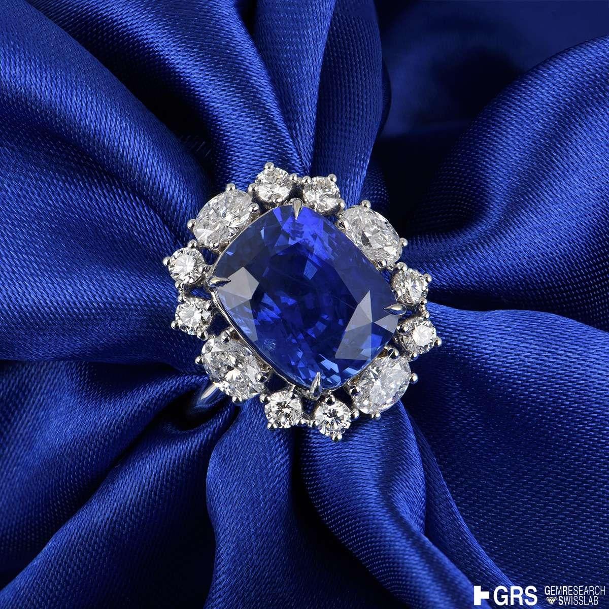An extraordinary 18k white gold sapphire and diamond ring. The ring is set to the centre with an exceptional Sri Lankan cushion cut natural sapphire weighing 9.08ct, displaying a Cornflower blue hue, with no indications of heat treatment. The