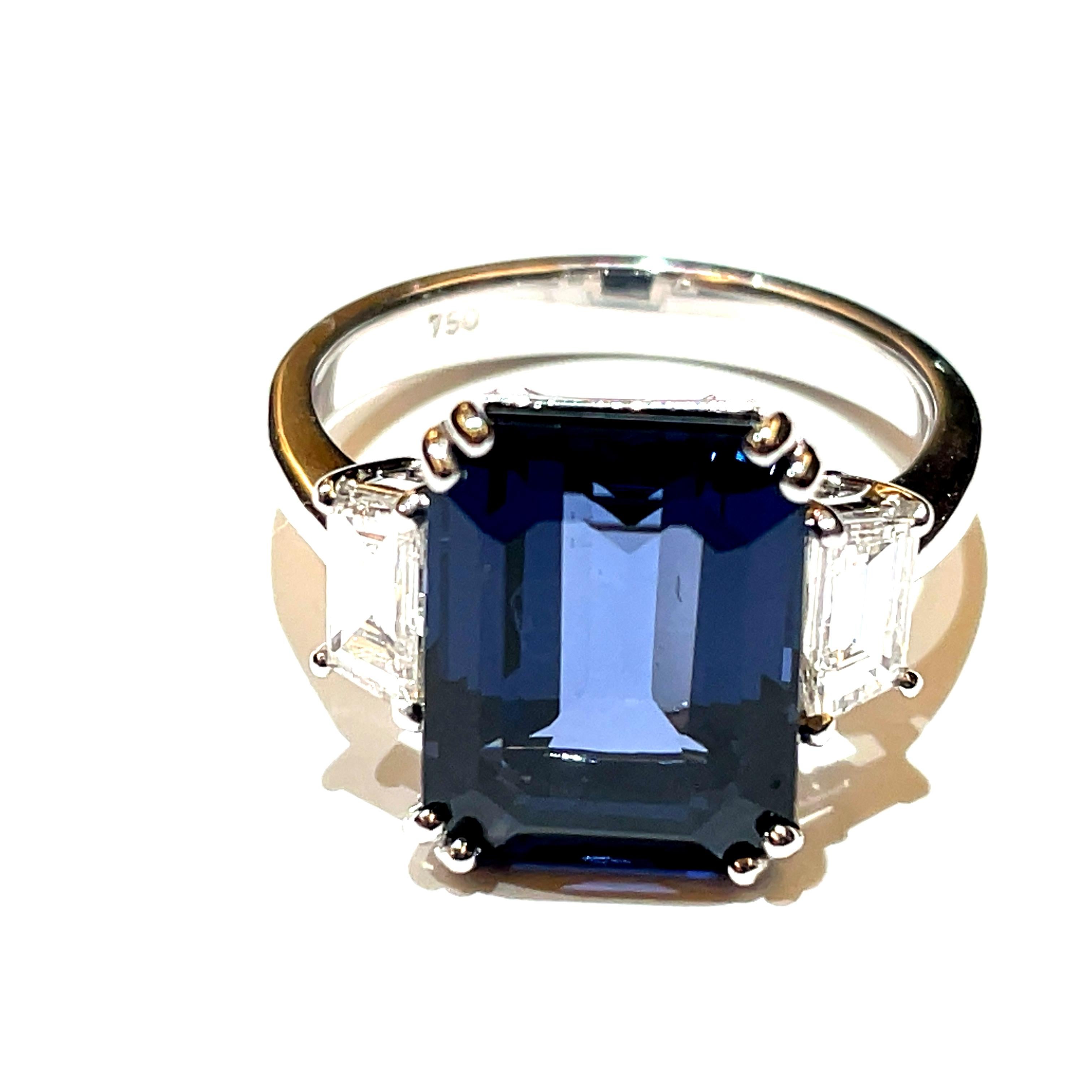 Centrally positioned is a stunning Greyish Blue Spinel Octagon, weighing a substantial 6.91 carats, sourced from Sri Lanka and certified by GRS as 'No Heat.' 

This exceptional gemstone exhibits a mesmerizing greyish-blue hue, reminiscent of serene
