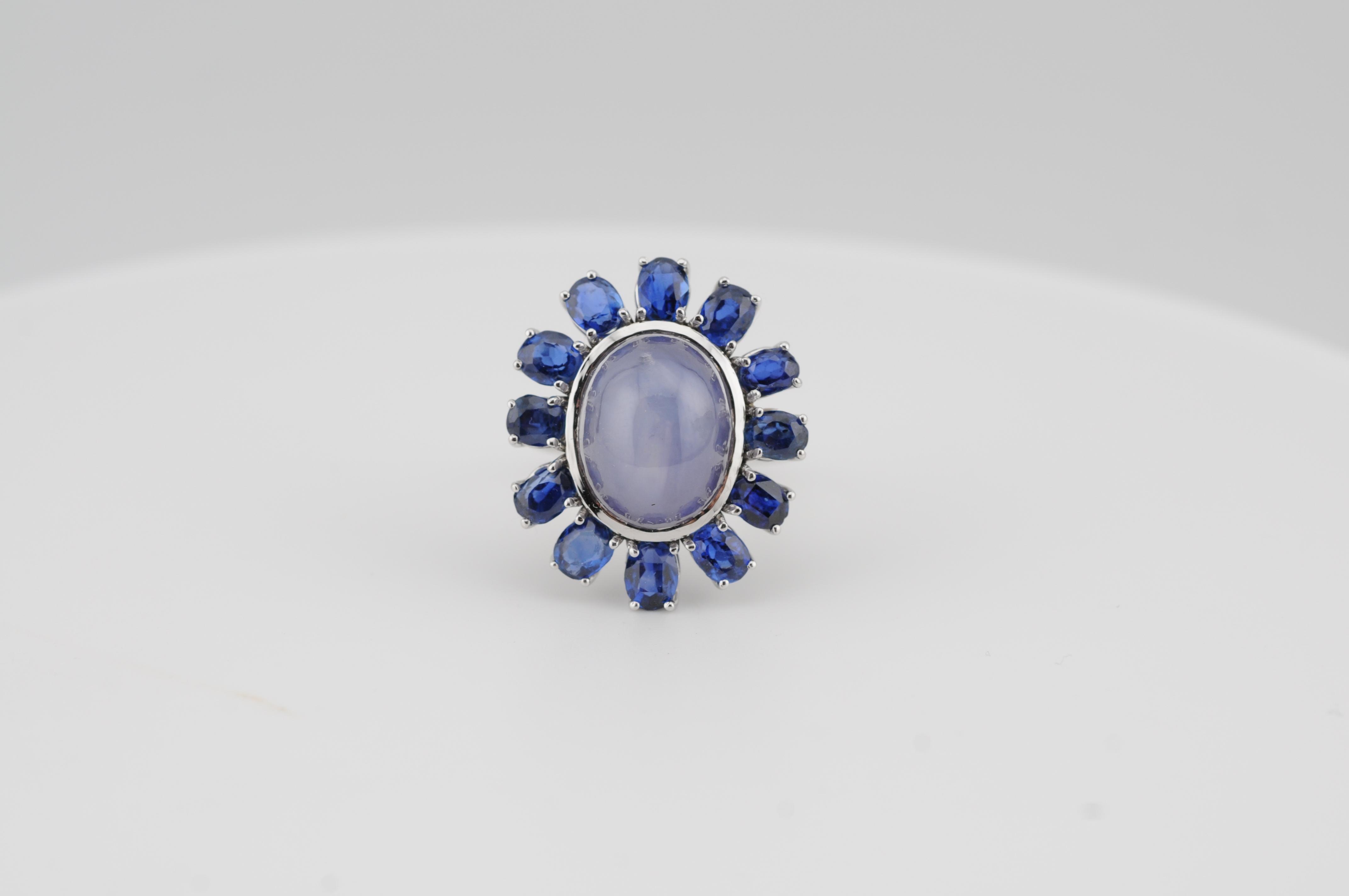 Ein auffälliger Ring mit einem 15,5-karätigen natürlichen Sternsaphir aus Ceylon, der einen ausgeprägten und gut zentrierten sechsstrahligen Stern aufweist. Er ist von zwölf königsblauen, natürlichen Saphiren aus Ceylon von insgesamt etwa 1,5 Karat
