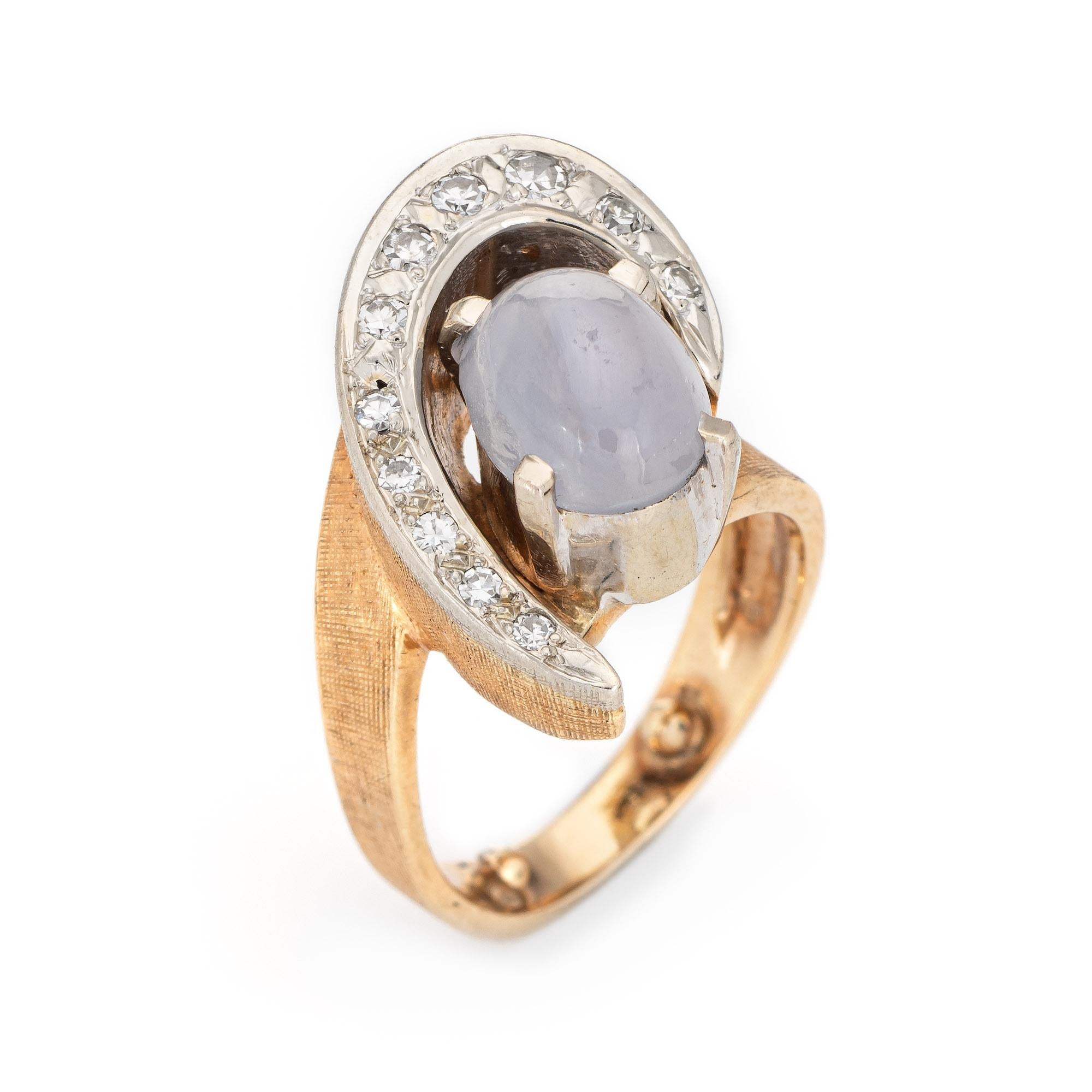 Stylish vintage natural star sapphire & diamond ring (circa 1960s) crafted in 14 karat yellow gold. 

Cabochon star sapphire measures 9.5mm x 5mm (estimated at 2.50 carats) accented with an estimated 0.15 carats of diamonds (estimated at G-H color