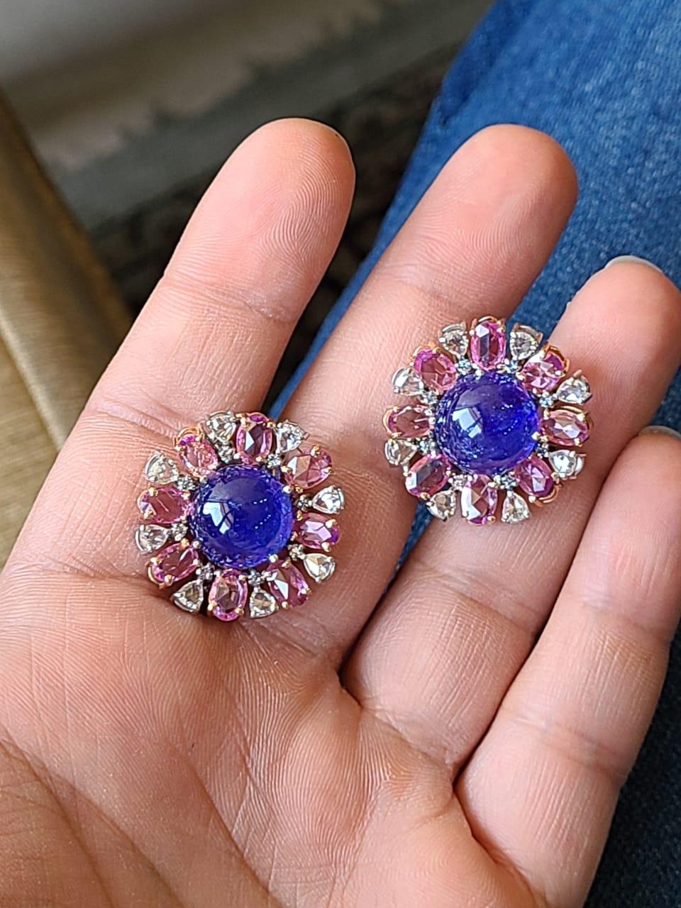 A very bold and beautiful pair of Tanzanite & Pink Sapphire Stud Earrings set in 18K White Gold & Diamonds. The weight of the Tanzanite Cabochons is 20.63 carats. The Tanzanites are responsibly sourced from Tanzania. The weight of the Pink Sapphires