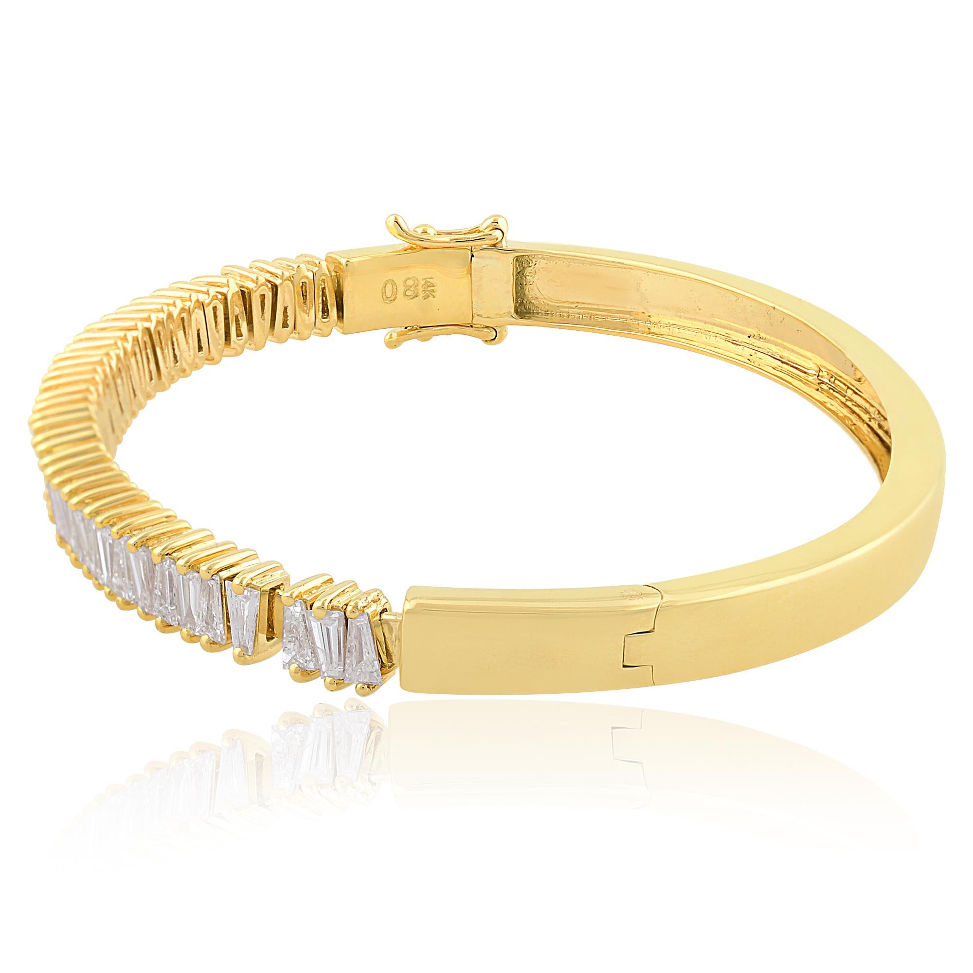 Indulge in the timeless elegance of this Natural Tapered Baguette Diamond Bangle Bracelet, meticulously crafted in 14 Karat Yellow Gold. This exquisite piece of jewelry embodies sophistication and grace, perfect for adding a touch of glamour to any