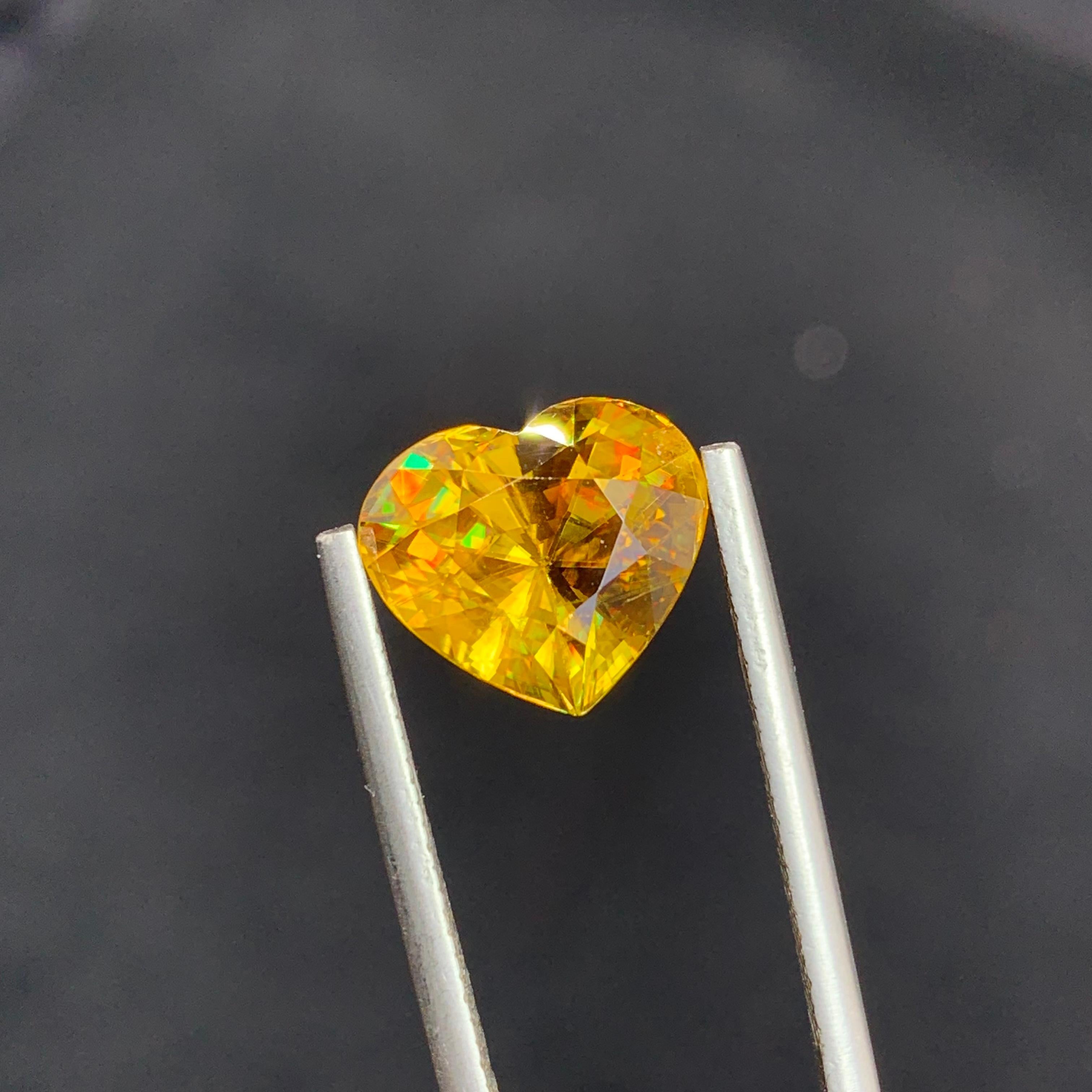 Loose Sphene
Weight: 5.30 Carats
Dimension: 10.2 x 11.6 x 6.8 Mm
Origin: Warsak Pakistan
Shape: Heart 
Color: Yellow Fire
Treatment: Non
Certificate: On Demand

Sphene, also known as titanite, is a remarkable and lesser-known gemstone that has
