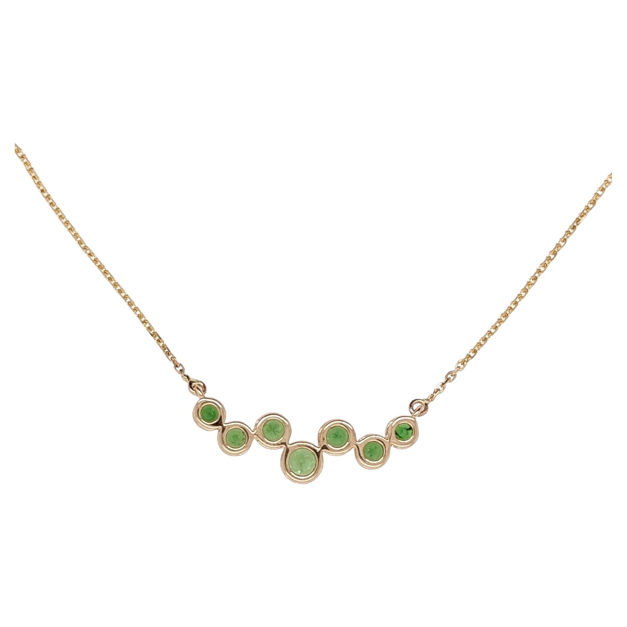This playful pendant features 7 all natural tsavorite center stones in solid 14k yellow gold with a solid 14k yellow gold chain attached ( 0.95mm Diamond Cut Cable Chain - centered at 16 inches). This piece is ready to ship with the tsavorite shown