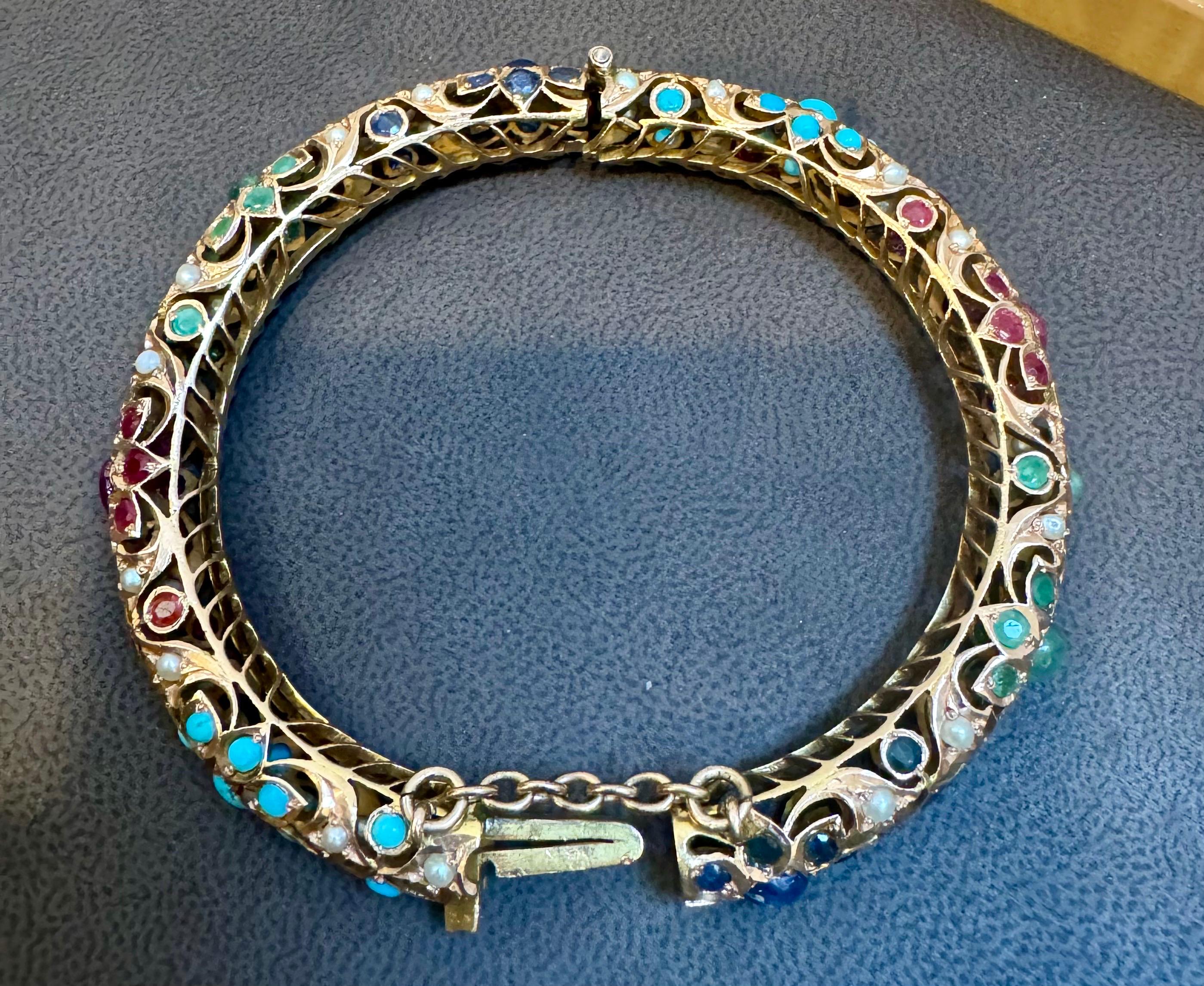 Vintage  Turquesa natural Esmeralda Rubí Zafiro perla Brazalete de Oro Amarillo de 14 Kt 41 Gm
Una cosecha  pulsera brazalete de nuestra colección Estate es brillante con  redonda  cabujón de turquesa esmeralda rubí zafiro y perlas en estaciones