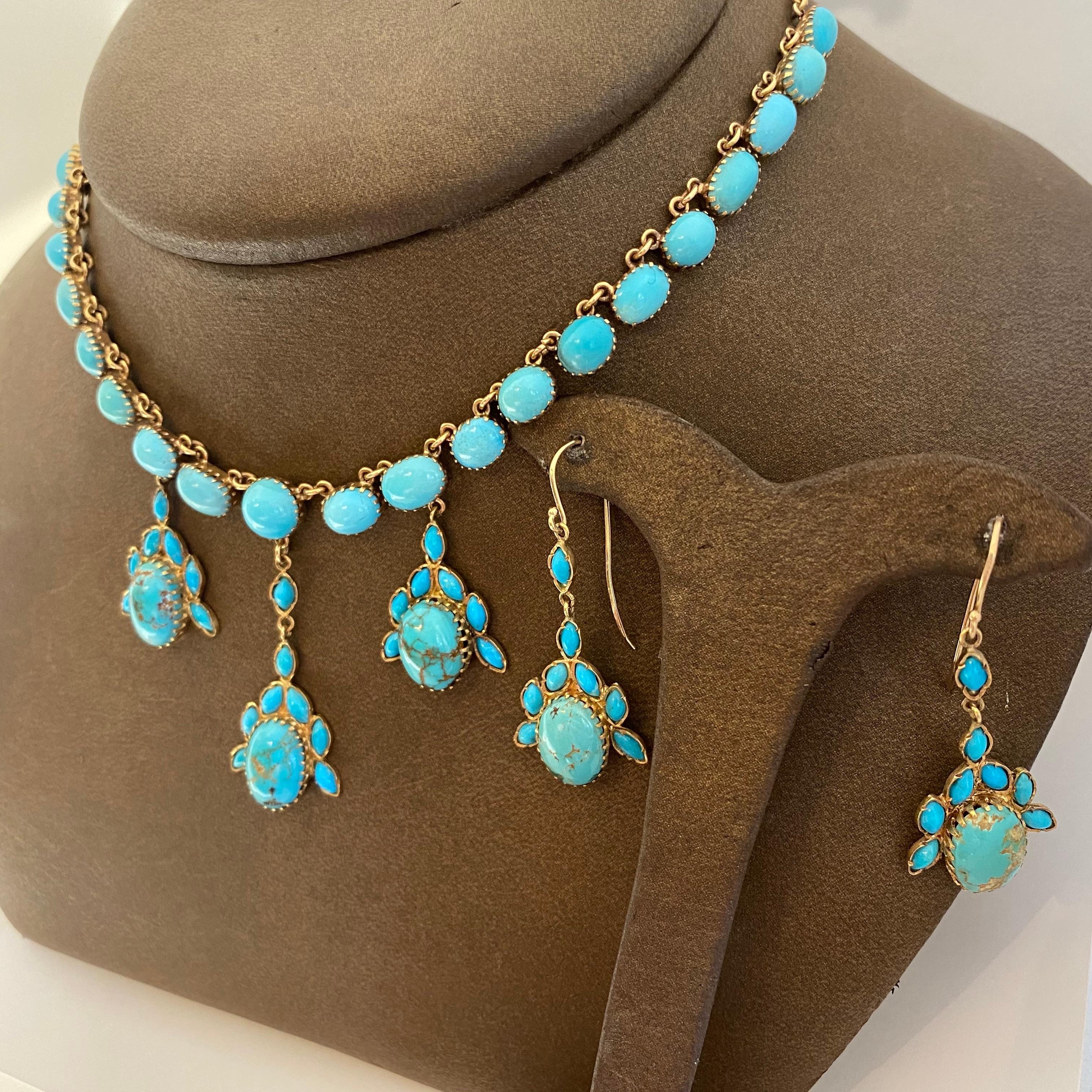 Beautiful estate necklace and earring suite designed in 18 karat yellow gold set with natural turquoise. The necklace has three graduated drops with oval and marquise cabochon turquoise gemstones. The earrings match with a fishhook earring wire.