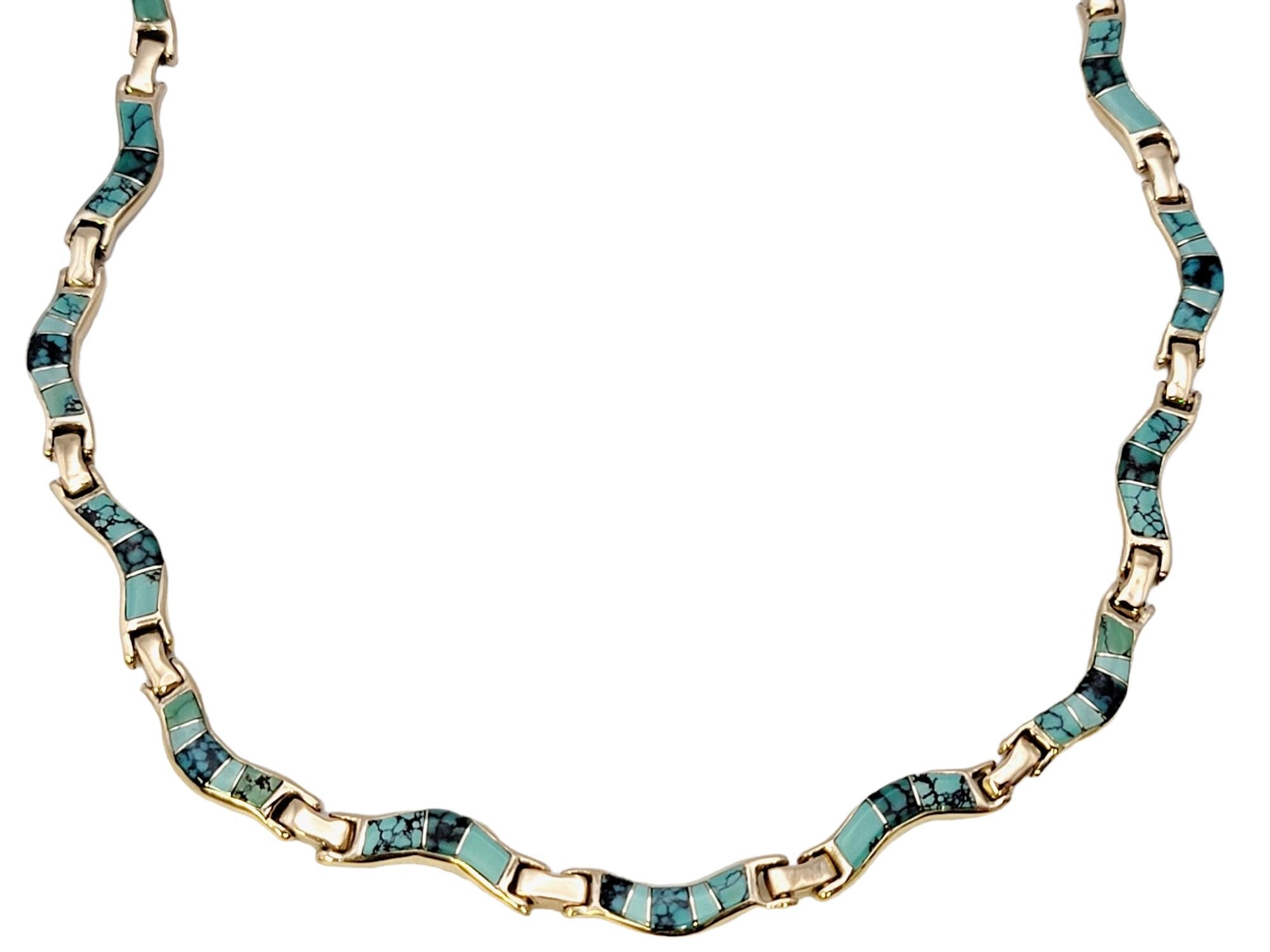 Indulge in the elegance of this captivating lady's turquoise inlay necklace, meticulously crafted in lustrous 14 karat yellow gold in a wavy design. This stunning piece harmoniously combines the brilliance of precious metal with the vibrant allure