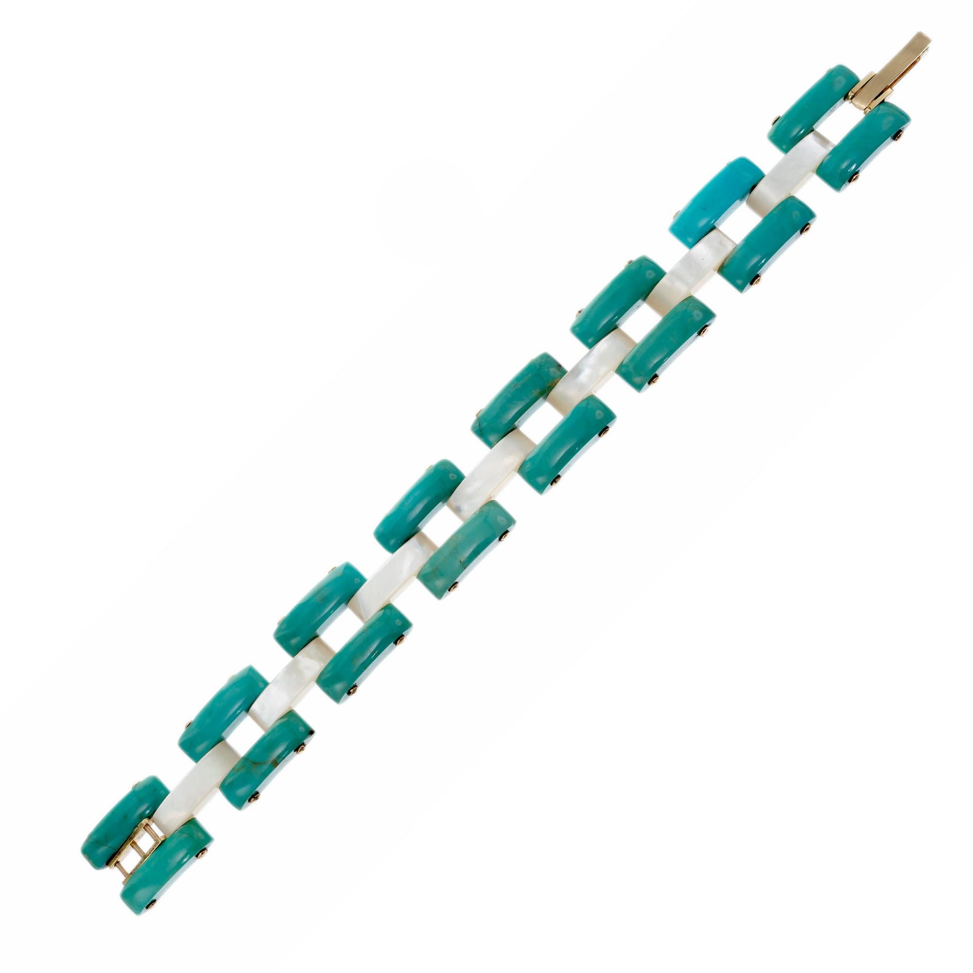 Natural turquoise and mother of pearl link bracelet with 14k gold rivets and catch. Circa 1940's. 7 inches in length. 

16 greenish blue turquoise bars 
7 white iridescent mother of pearl bars
14k yellow gold 
Stamped: 14k
21.9 grams
Bracelet: 7