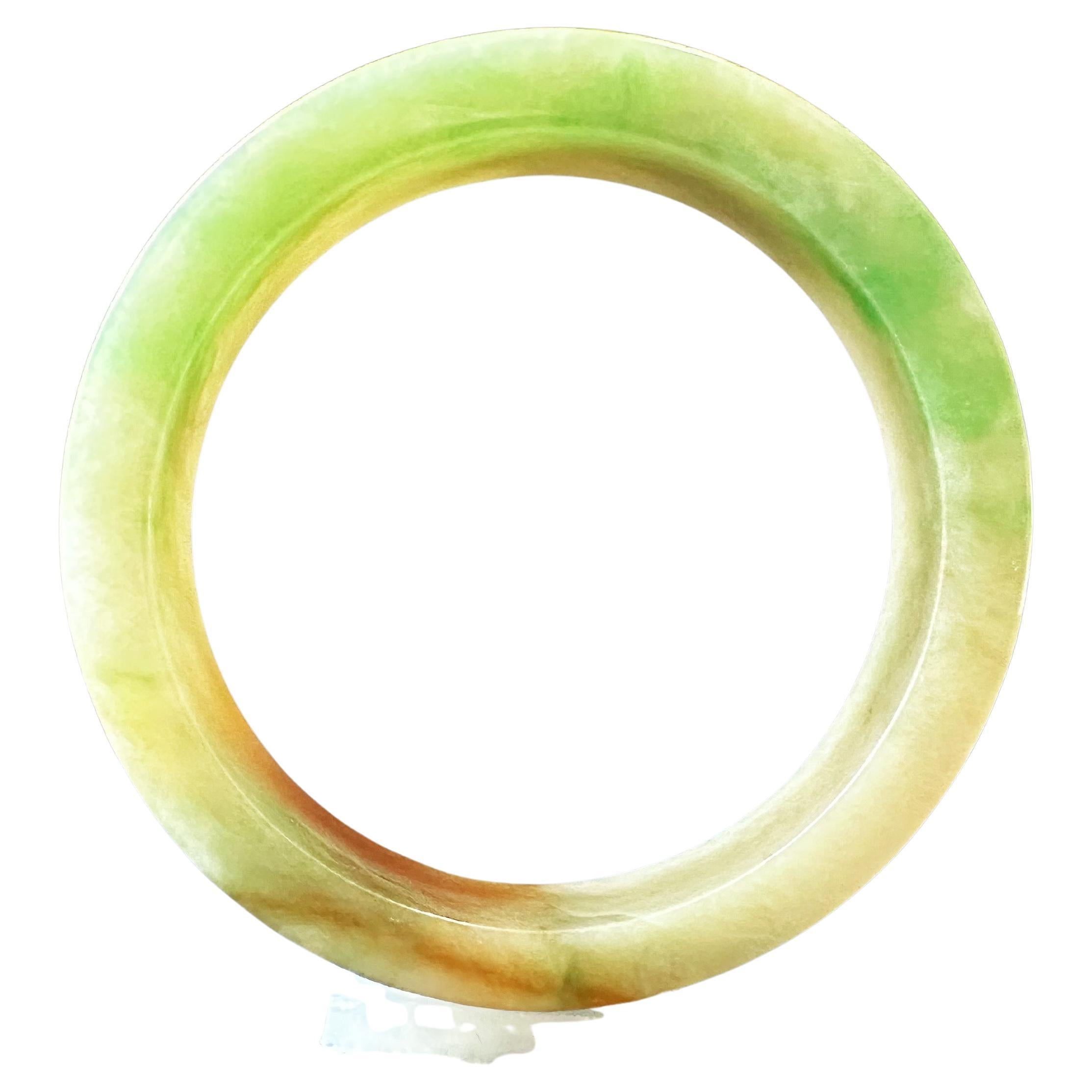 Discover the exquisite beauty of our 100% natural, untreated, and undyed Grade A jadeite bangle from Myanmar. This stunning piece features a rare tri-color combination of vibrant yellow, green, and red, showcasing the unique artistry of Mother