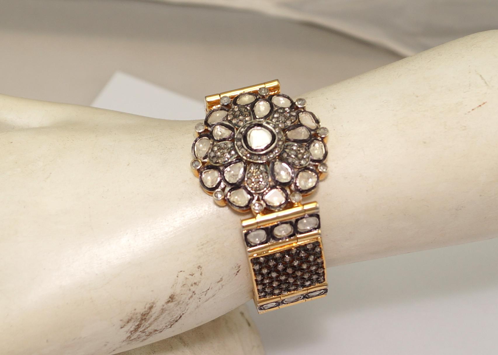 This vintage style diamond silver and yellow gold plating hinged bangle consists of:

Diamond- 12.40cts
Diamond type: Rose cut diamonds and uncut polki diamond
Diamond color:  white and tinted yellow
Diamond origin- Natural
Metal: Silver
Metal