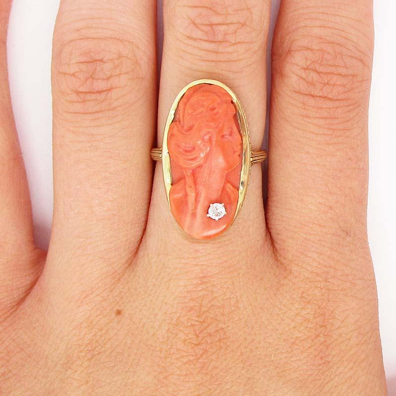 This is an incredible Art Deco ring in 16k yellow gold with an absolutely stunning natural undyed red coral cameo center. The ring itself is in gorgeous yellow gold engraved with a finely detailed hand engraved design that creates the illusion of a