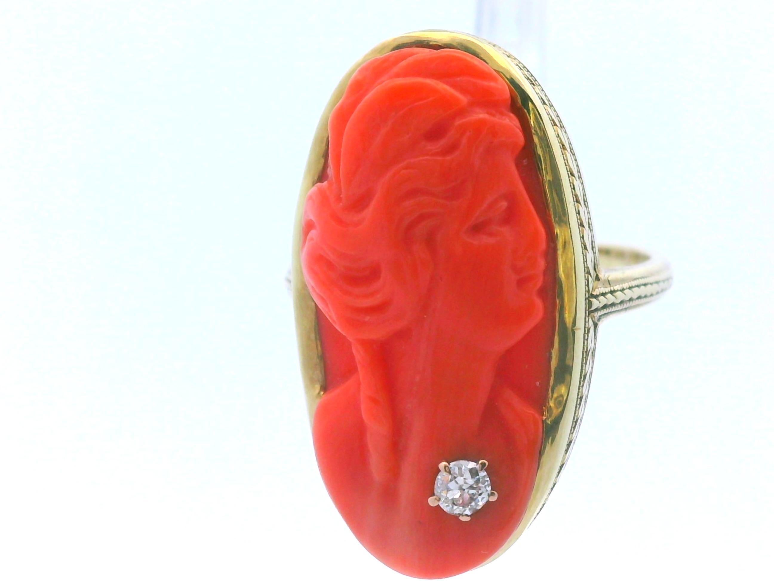 This is an incredible Art Deco ring in 16k yellow gold with an absolutely stunning natural undyed red coral cameo center. The ring itself is in gorgeous yellow gold engraved with a finely detailed hand engraved design that creates the illusion of a