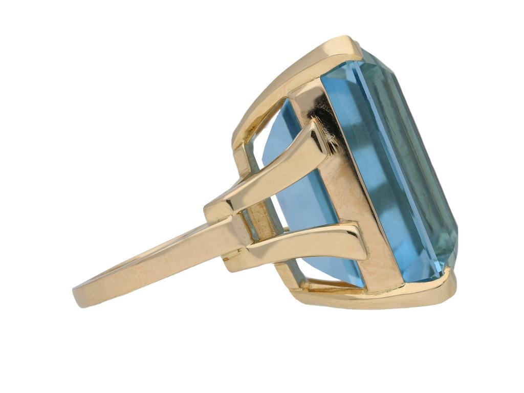 Aquamarine cocktail ring. Centrally set with a octagonal emerald-cut natural unenhanced aquamarine in an open back four claw setting with an approximate weight of 44.00 carats, to an impressive solitaire design featuring a structured openwork