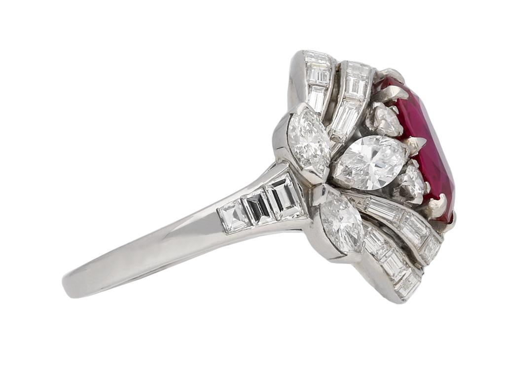 Anillo de rubí birmano y racimo de diamantes. Engastado con un rubí birmano natural sin realzar, ovalado y talla antigua en el centro, en garra abierta por detrás, con un peso aproximado de 2,43 quilates, flanqueado por cuatro diamantes redondos