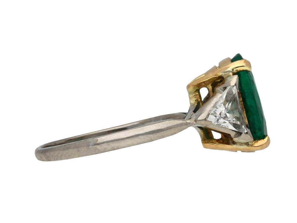 Art Deco Colombian emerald and diamond ring. Set to centre with an oval old cut natural Colombian emerald with no colour enhancement and minor clarity enhancement in an open back claw setting with an approximate weight of 2.09 carats, further set