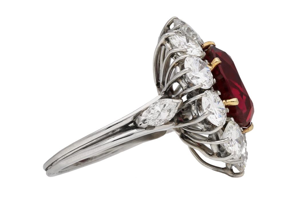 Vintage ruby and diamond coronet cluster ring. Set with a natural unenhanced cushion shape old cut Siam ruby to centre in an open back yellow gold claw setting with an approximate weight of 6.19 carats, encircled by a single row of ten round