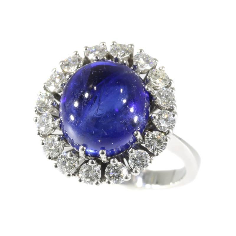 A vintage ring in 18 karat white gold set with a natural untreated cabochon blue sapphire 7.11 carat, most probably from Sri Lanka (former Ceylon) and 16 modern brilliant cut diamonds totaling 1.20 carat (color and clarity grade: F/H, vs/si). Top of