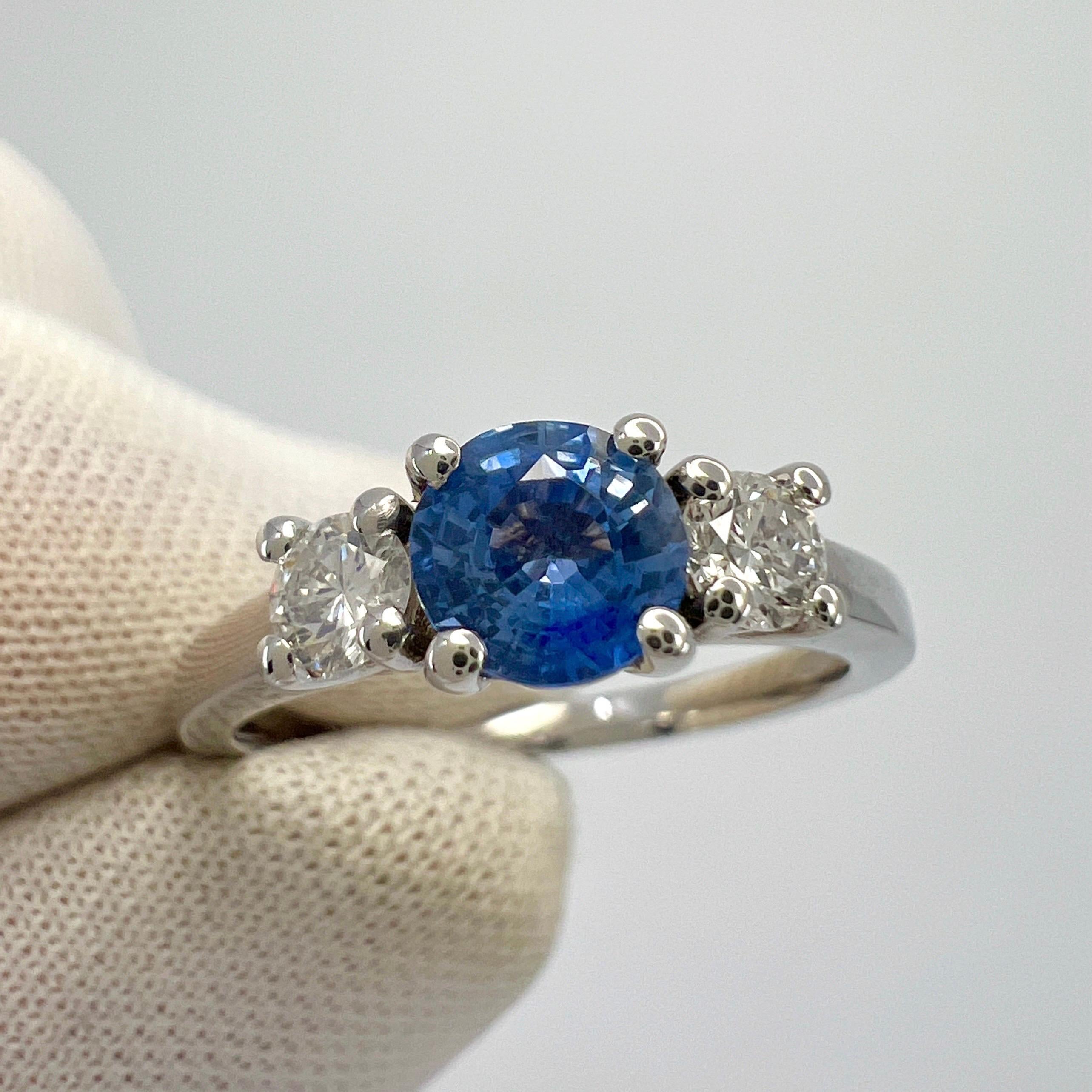 Natural Vivid Blue Sapphire And Diamond Three Stone 18k White Gold Ring.

5mm Centre Ceylon sapphire with a vivid blue colour and excellent clarity, a very clean stone. Also with an excellent round cut showing lots of brightness and light return.