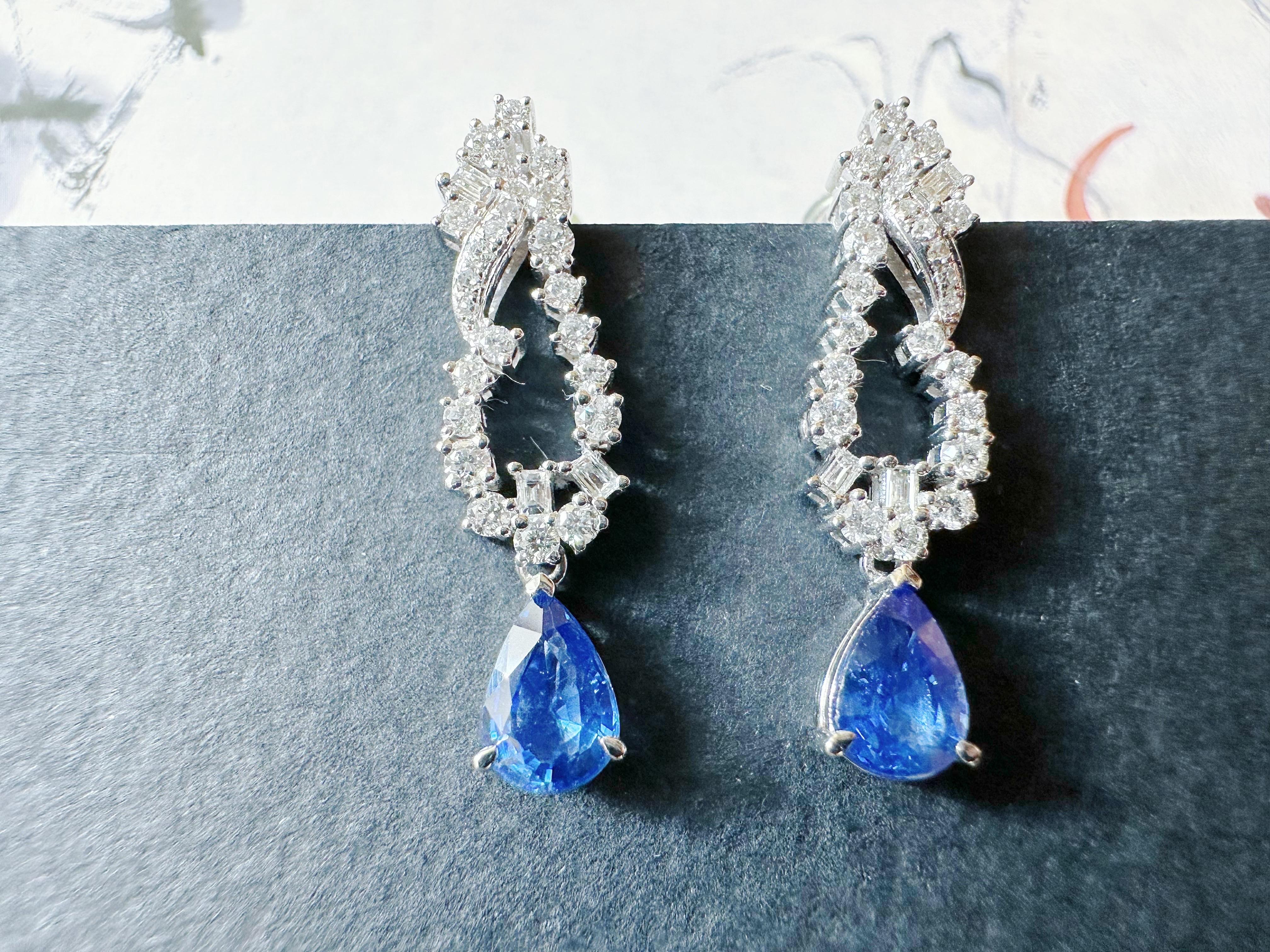 Wir präsentieren ein bezauberndes Paar Ohrringe mit zwei exquisiten blauen Tropfen-Saphiren aus Sri Lanka, die elegant mit Brillanten verziert sind. Jedes Stück ist individuell gestaltet und ein echtes Unikat mit einer modernen und minimalistischen