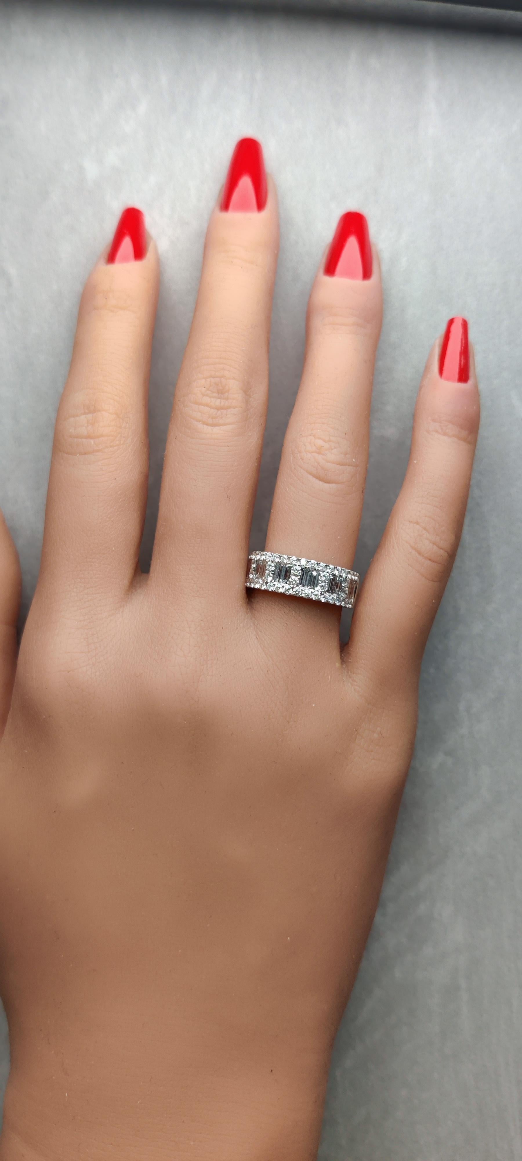 El clásico anillo de diamantes de RareGemWorld. Montada en un precioso engaste de oro blanco de 18 quilates con diamantes blancos baguette naturales complementados con melee de diamantes blancos redondos naturales. ¡Esta banda está garantizada para