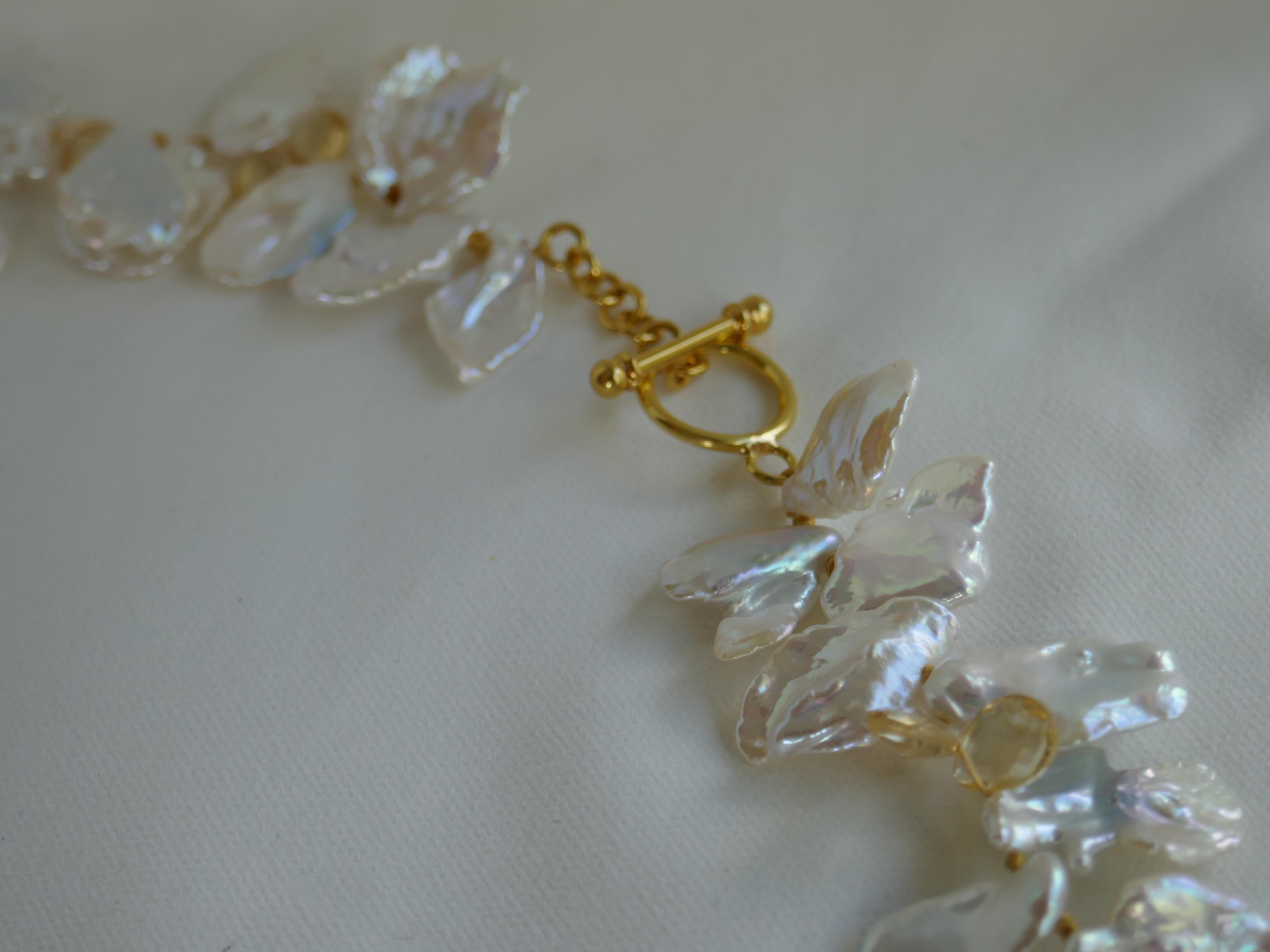 This necklace is spectacular. The white keshi pearls have great luster with little blemishes and are interspersed with citrine faceted briolettes with an 18k gold (not plated) clasp. The necklace is knotted on yellow silk thread. The keshi pearls
